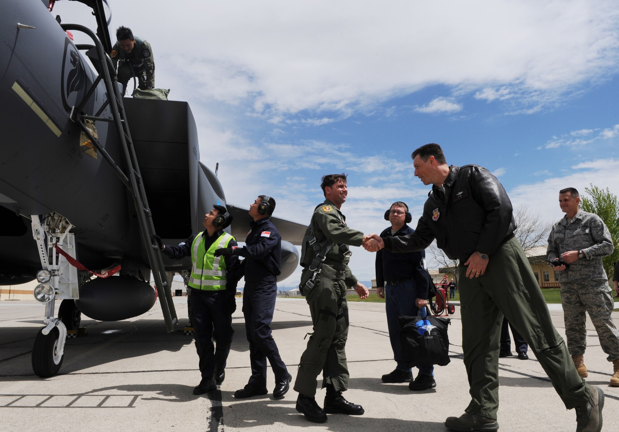 MOUNTAIN HOME AIR FORCE BASE, Idaho - Col. John Bird, 366th Fighter Wing commander, shakes hands with Lt. Col. Keith Gibson, training squadron U.S. commander, after arriving in one of the first F-15SG fighter jets belonging to the Republic of Singapore air force May 6.The F-15SG is an advanced version of the F-15 Strike Eagle currently flown by two squadrons at Mountain Home AFB. During a ceremony May 18, the 366th Fighter Wing, in conjunction with the Republic of Singapore air force, will officially activate the 428th Fighter Squadron “Buccaneers” here. The unit will include approximately 180 active duty and 130 support personnel as part of a long-standing partnership with the United States to train its aircrews. Over the life of the program, as many as 2,000 active duty RSAF personnel will live and work on the base. (U.S. Air Force photo/ Airman 1st Class Renishia Richardson)