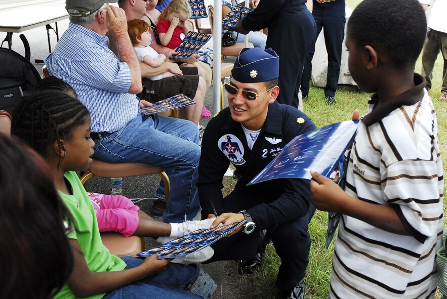 Maj. John Baum, who flies the USAF Thunderbirds No. 2 jet, signs an autograph for TaTonisha Tillman, who is a part of the Make-A-Wish Program, while her cousin looks on. U. S. Air Force photo by Mike Malone