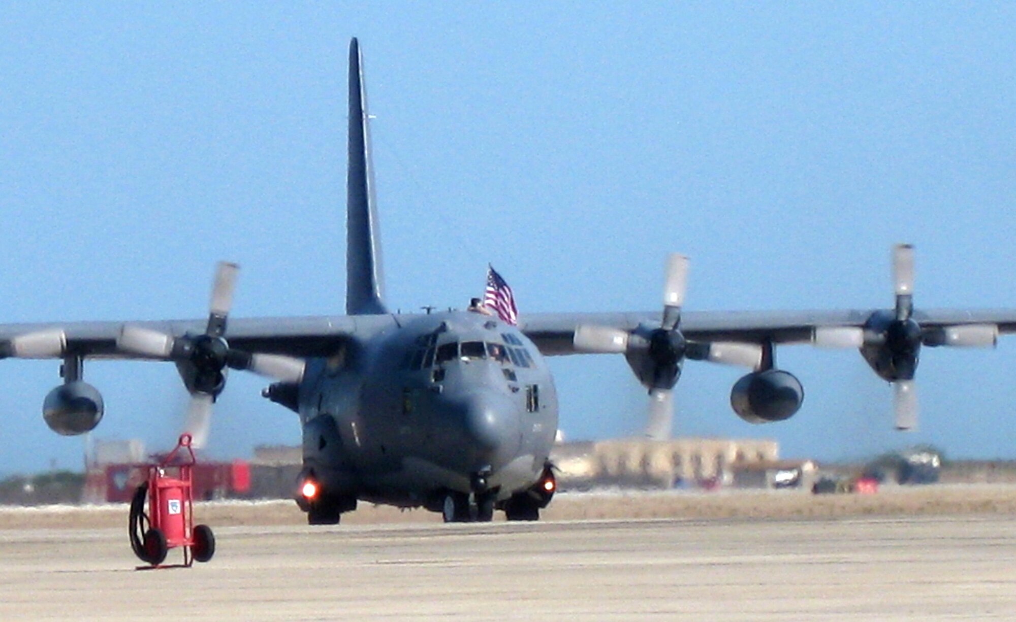 An Airman from the 920th Rescue Wing waves the American flag through the porthole of an HC-130P/N Hercules aircraft May 5, 2009, as it and another aircraft taxi onto the Patrick Air Force Base, Fla., flightline. Thirty Airmen returned safely to Patrick from the Horn of Africa, where they provided combat search and rescue support to the region, which included the countries of Djibouti, Eritrea, Ethiopia and Somalia. The Air Force Reserve Command wing had reservists in Africa for two months. (U.S. Air Force photo/Kristen Kincade)