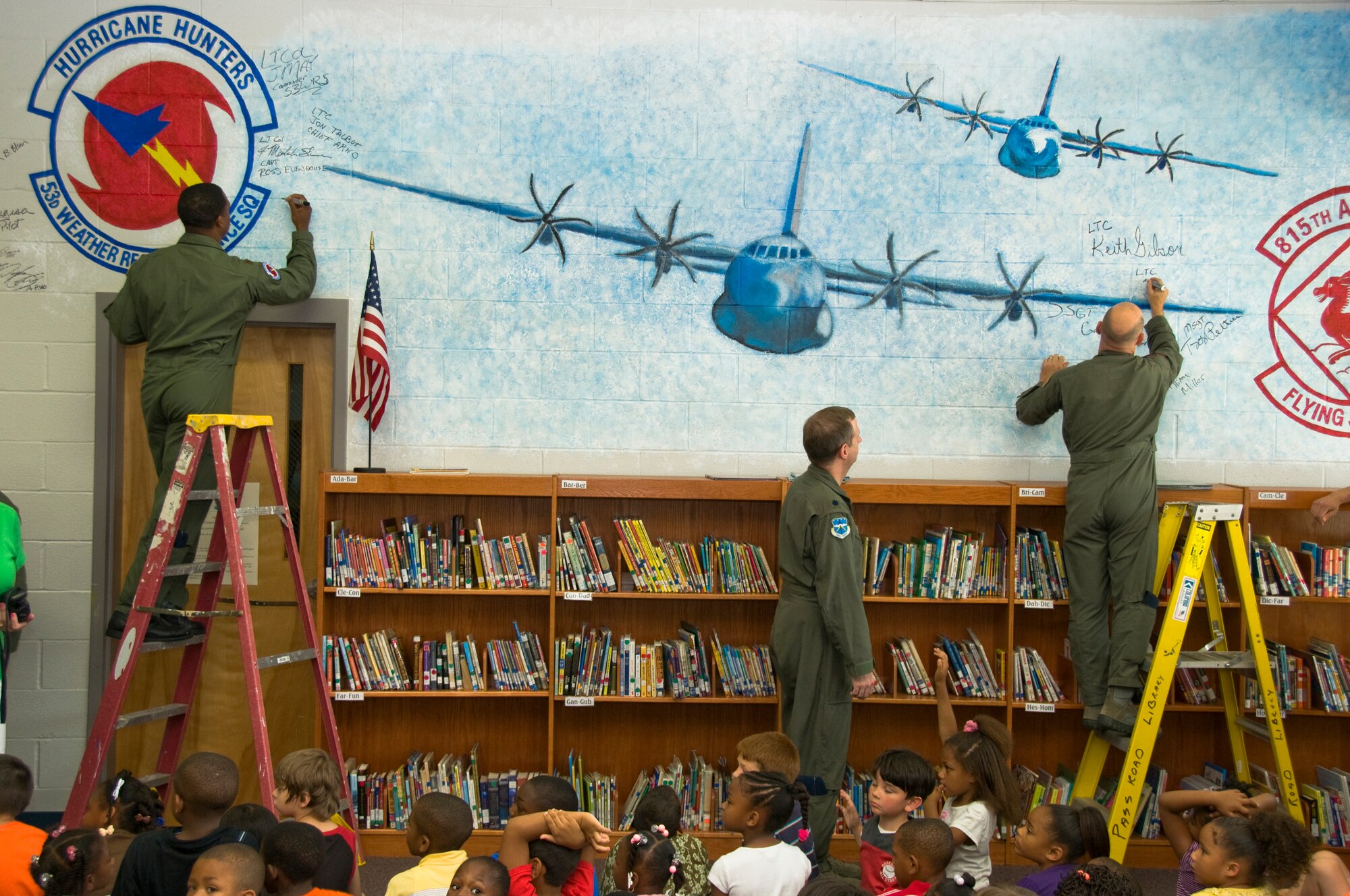 More than 200 kids from Pass Road Elementary school in Gulfport, Miss., packed into the library May 6 to watch as members of the 53rd Weather Reconnaissance Squadron and the 815th Airlift Squadron signed their names on a wall size mural painted in honor of their service. We wanted to dedicate this mural to you guys because you are our heroes on the Coast. You?ll like Hollywood; these kids hear about you all the time, but they never get to see you. This is their Hollywood, said Ms. Penny Walton, library media specialist, Pass Road Elementary.