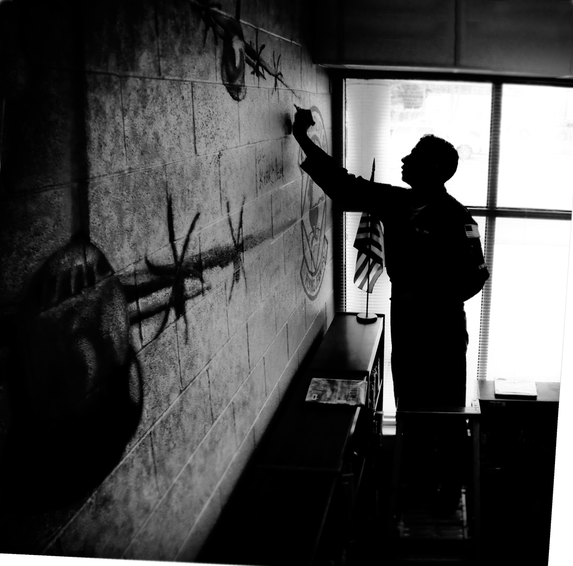 Capt. Mark Suckow, pilot, 815th Airlift Squadron, signs his name on a mural painted in the library at Pass Road Elementary, Gulfport, Miss. ?You guys are Hollywood to these kids, and we thought it would be a great idea if you could come sign it,? said Ms. Penny Walton, library media specialist, Pass Road Elementary. The mural was painted to express thanks for the services Citizen Airmen of the 403rd Wing provide. (U.S. Air Force Photo by 1st. Lt. J. Justin Pearce)