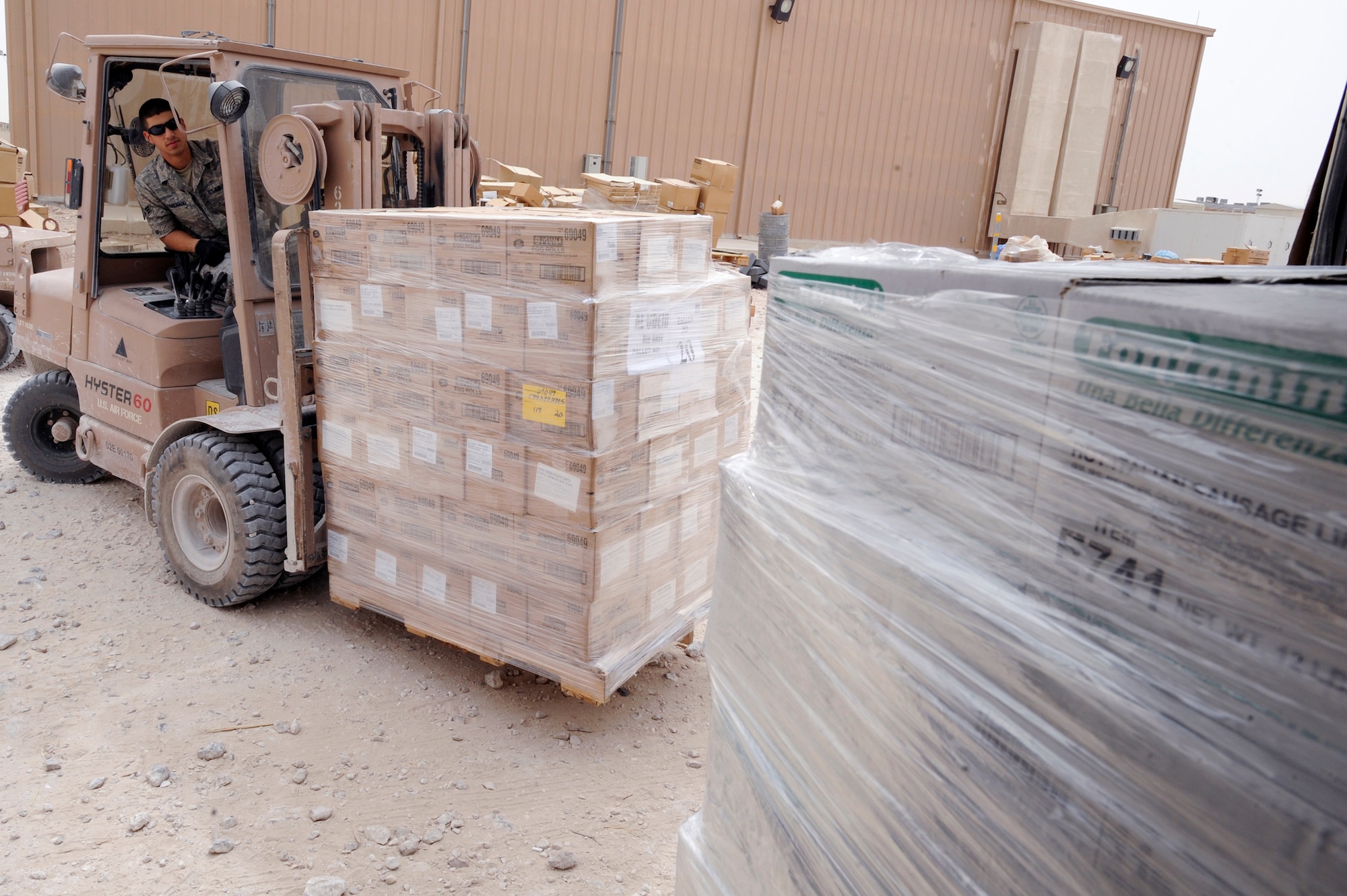 Senior Airman Leandro Corchado, a rations clerk with the 379th Expeditionary Force Support Squadron, brings a pallet of frozen foods to a cold storage container to be stored until further use here, May 6, 2009, in an undisclosed location in Southwest Asia.  Airman Corchado and fellow rations clerk process over 81,000lbs of food weekly. Airman Corchado hails from Miami, Fla. and is deployed from Nellis Air Force Base, Nev., in support of Operations Iraqi and Enduring Freedom and Combined Joint Task Force - Horn of Africa.  (U.S. Air Force Photo by Staff Sgt. Joshua Garcia/released)