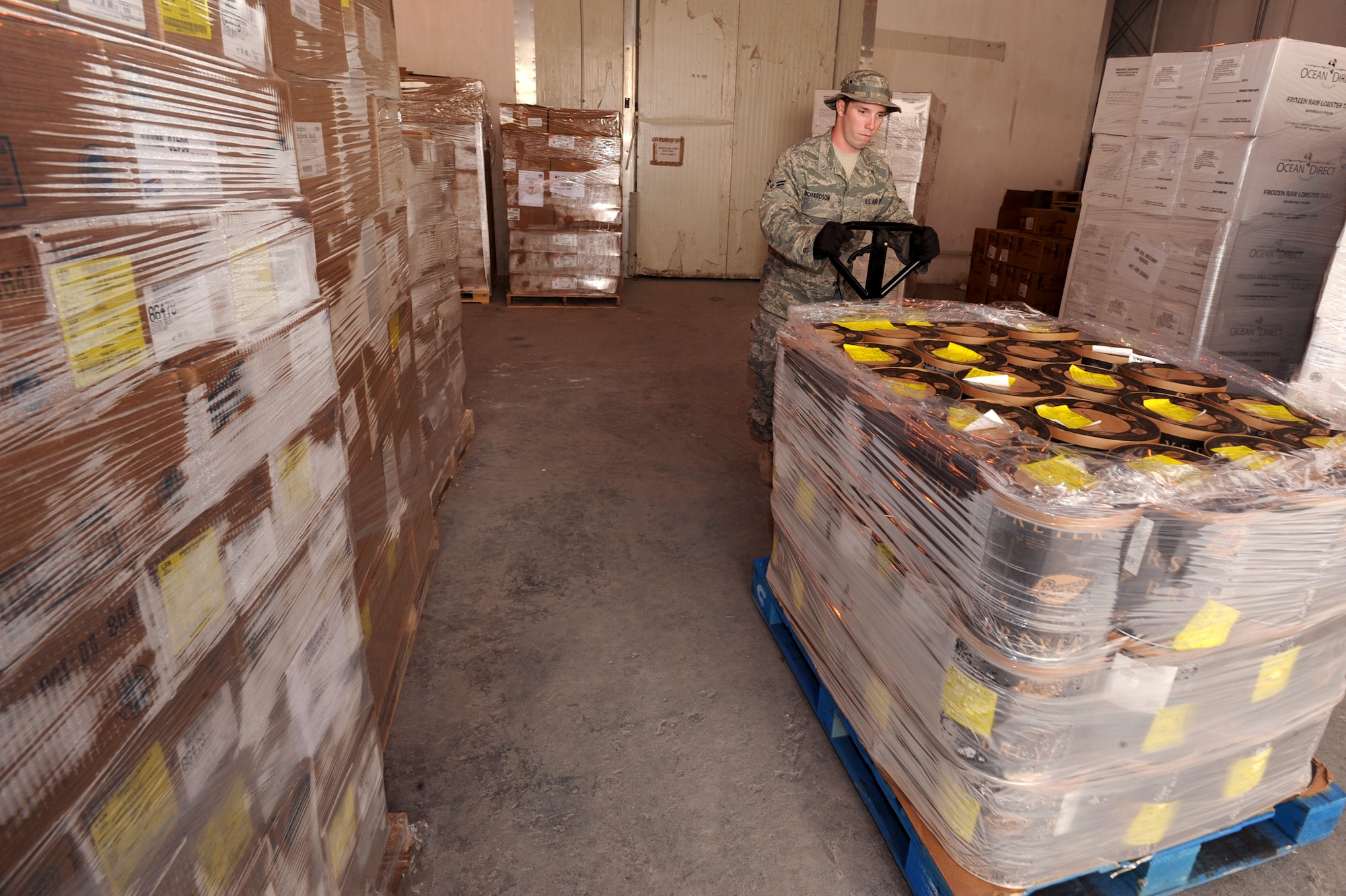 Airman 1st Class Martin Richardson, a rations clerk with the 379th Expeditionary Force Support Squadron, stages a pallet of ice cream for transfer to a cold storage container, May 6, 2009, in an undisclosed location in Southwest Asia.  After the food pallets arrive in this main receiving area they are organized, selected, and distributed to the individual dining facilities. Airman Richardson hails from Conway Ark., and is deployed from Little Rock Air Force Base, Ark. in support of Operations Iraqi and Enduring Freedom and Combined Joint Task Force - Horn of Africa.  (U.S. Air Force Photo by Staff Sgt. Joshua Garcia/released)