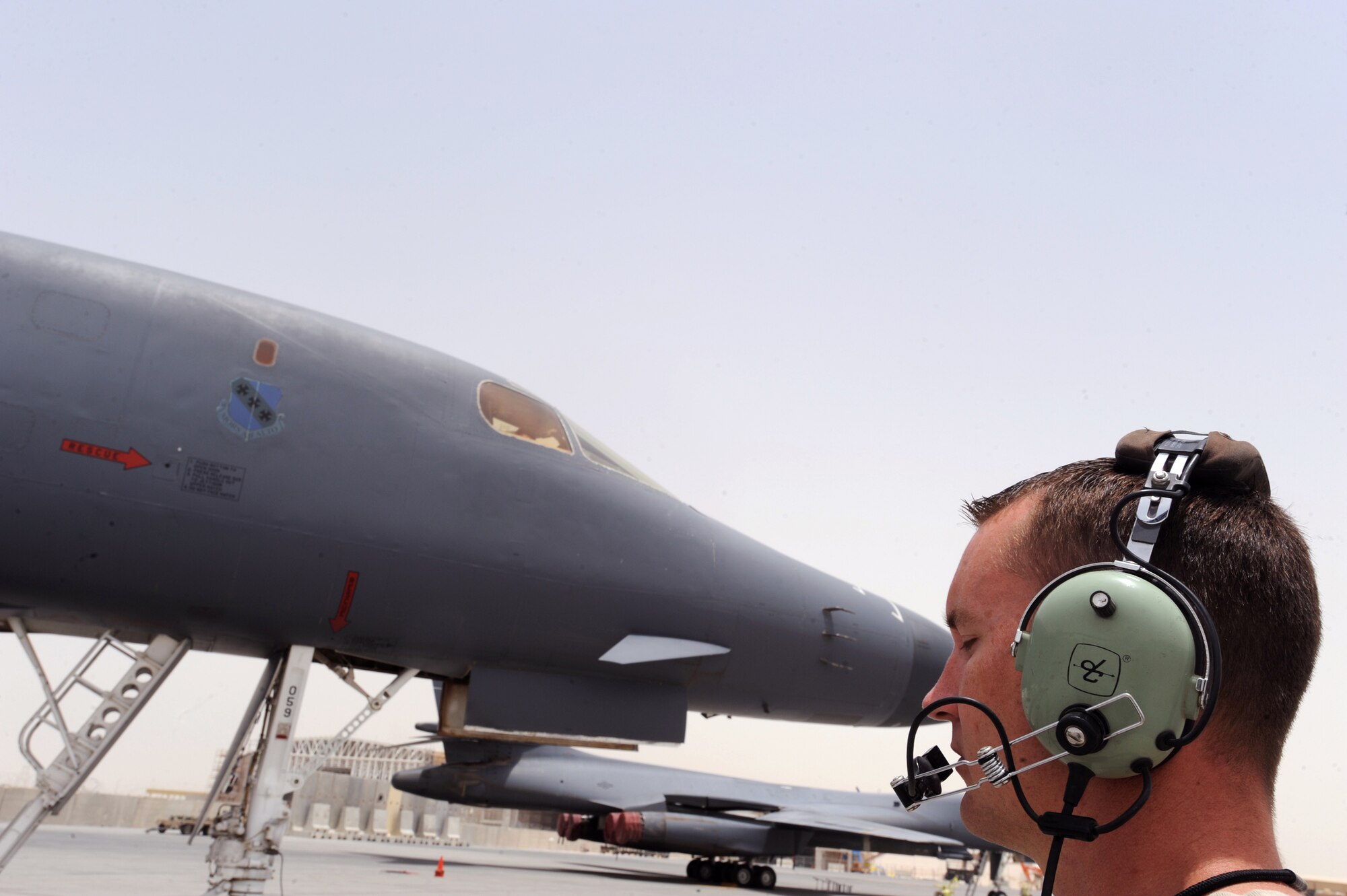 Staff Sgt. Bradley Davis, a B-1B Lancer Crew Chief with the 7th Aircraft Maintenance Unit, talks to the aircrew of a B-1B Lancer via hardwired communications during preflight checks, May 5, 2009, in an undisclosed location in Southwest Asia.  Communication between the crew chief and pilots is vital during preflight, because the crew chief visually verifies proper operation of the systems as they are checked. Sergeant Davis is native to Columbus, Miss. and is deployed from Dyess Air Force Base, Texas in support of Operations Iraqi and Enduring Freedom and Combined Joint Task Force - Horn of Africa.  (U.S. Air Force Photo by Staff Sgt. Joshua Garcia/released)