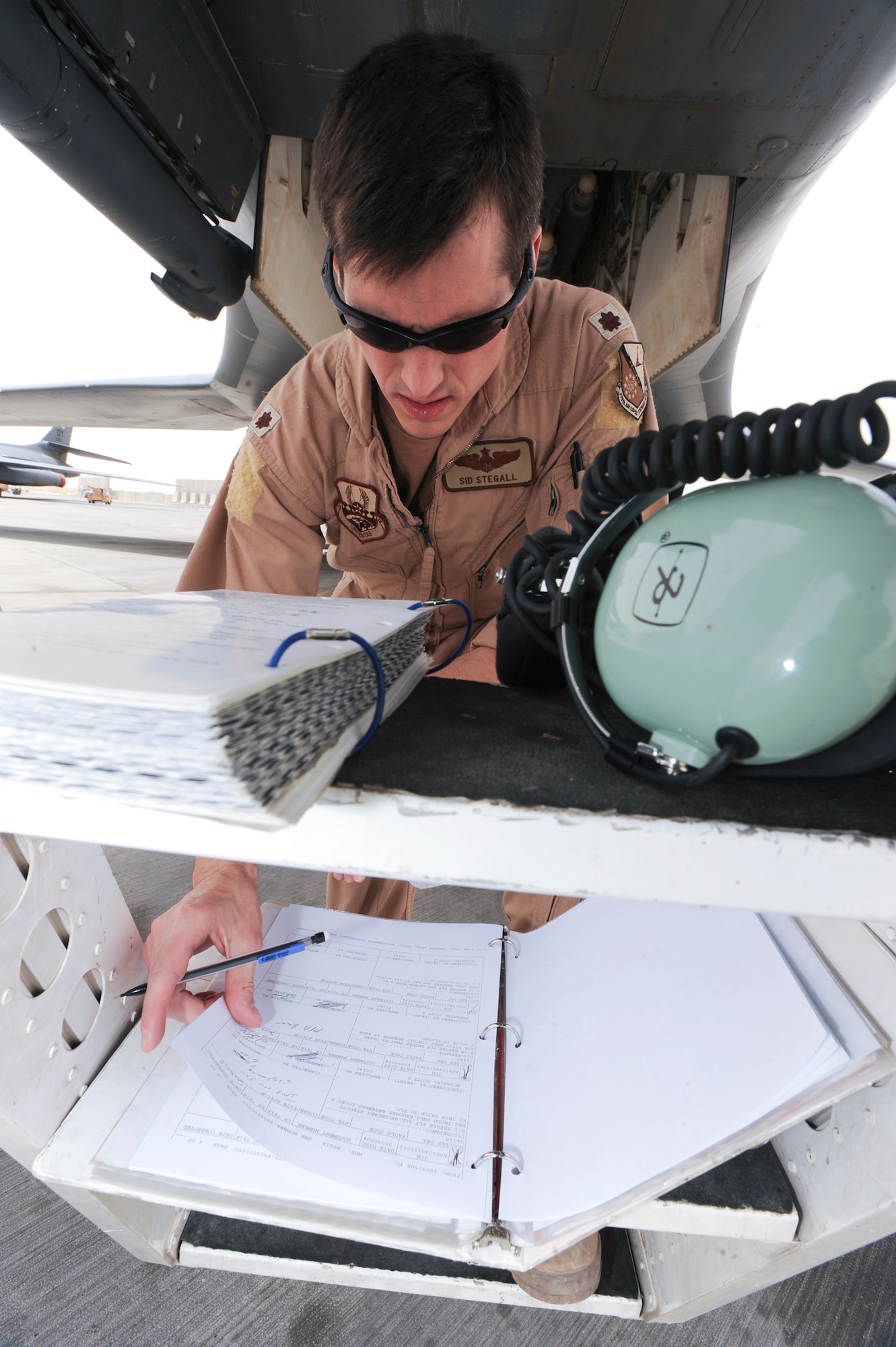 Major Sidney Stegall, 9th Expeditionary Bomb Squadron, reviews the maintenance paperwork prior to performing preflight checks on a B-1B Lancer here, May 5, 2009, in an undisclosed location in Southwest Asia.  Prior to every sortie the maintenance paperwork is reviewed to ensure the aircrew is aware of any discrepancies with the aircraft prior to performing preflight checks.  Major Stegall is native to Pine Log, Ga. and is deployed from Dyess Air Force Base, Texas in support of Operations Iraqi and Enduring Freedom and Combined Joint Task Force - Horn of Africa.  (U.S. Air Force Photo by Staff Sgt. Joshua Garcia/released)