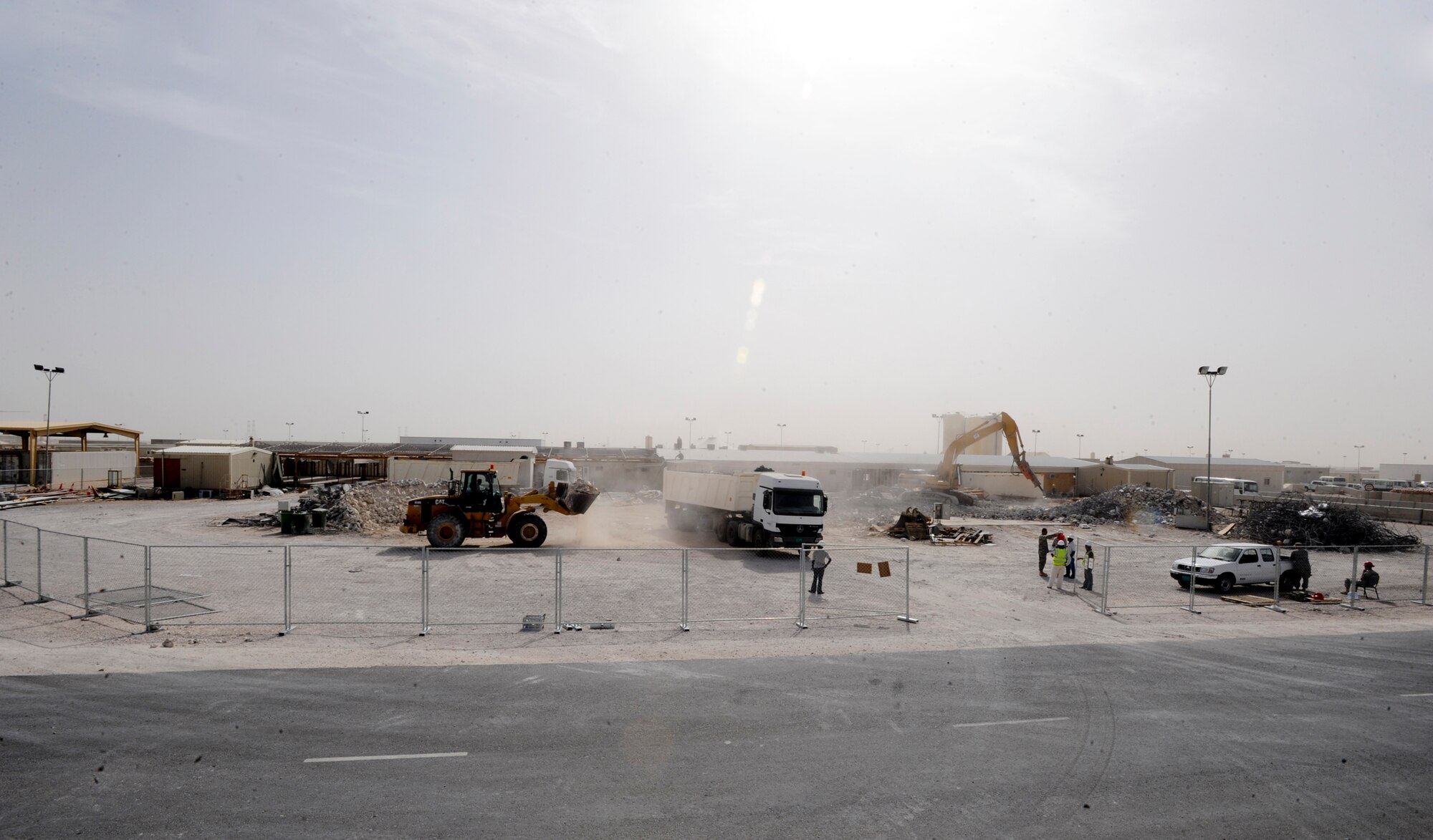 Heavy equipment operators break up and transport the concrete foundation surrounding the old Independence Dining Facility here, May 5, 2009, in an undisclosed location in Southwest Asia.  The Independence DFAC was recently replaced by a new facility nearby with state of the art kitchen equipment to serve servicemembers on base.  The facility supports operations of the 379th Air Expeditionary Wing and Operations Iraqi and Enduring Freedom and Combined Joint Task Force - Horn of Africa.  (U.S. Air Force Photo by Staff Sgt. Joshua Garcia/released)