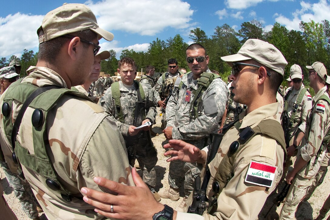 U.S. Army 1st Lt. Joshua Stuart-Shor, speaks with Iraqi army leaders through Iraq-born interpreter, Roger Algarawi, during a simulation training exercise emphasizing partnered security at the Joint Readiness Training Center on Fort Polk, La. Stuart-Shor, a platoon leader, is assigned to the 82nd Airborne Division's Company B, 1st Battalion, 504th Parachute Infantry Regiment.