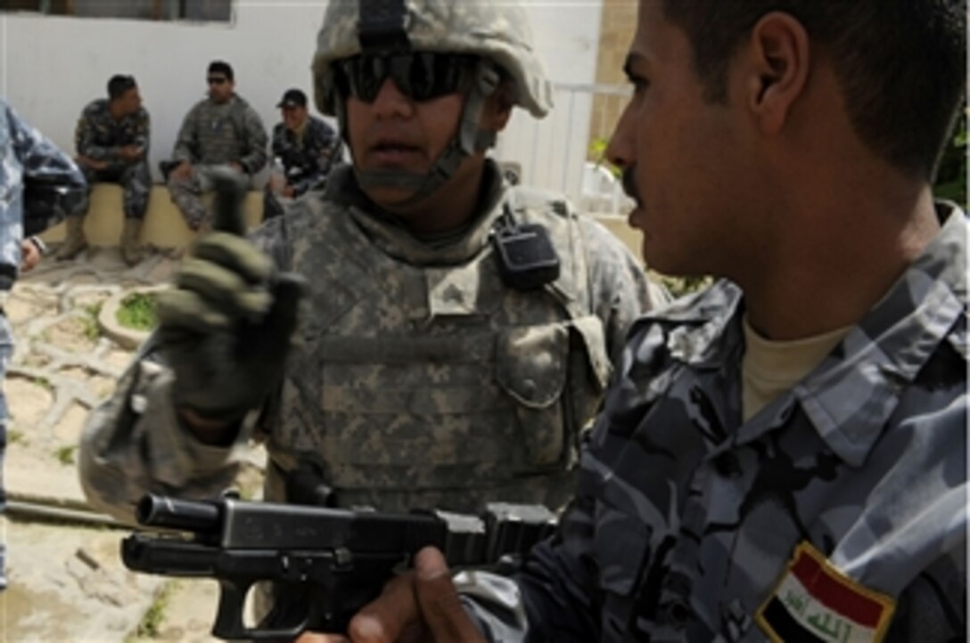 U.S. Army Sgt. Johnny Garcia, with the 302nd Military Police Company, discusses building entry procedures with an Iraqi Police officer during training in Mosul, Iraq, on April 29, 2009.  