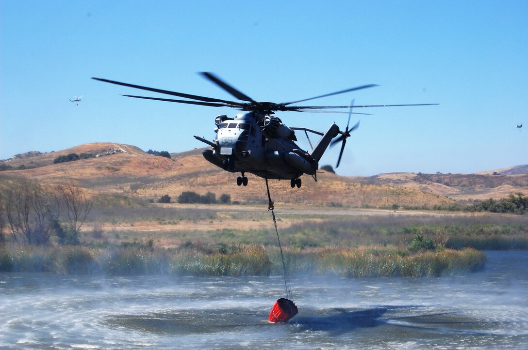 A CH-53E helicopter glides down to fill up a water basket at Pulgas Lake during the 2nd Annual Firefighting Exercise on Camp Pendleton, May 7. The exercise was established after the October 2007 Southern California wildfires.