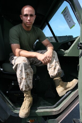 Pfc. Owen O. Valdivia, a motor transportation mechanic with Combat Logistics Company 36, sits in a Mark 48/16 in the CLC-36 Motor Transportation Lot here. Valdivia overcame the loss of his best friend to a motorcycle accident by joining the Marine Corps.
