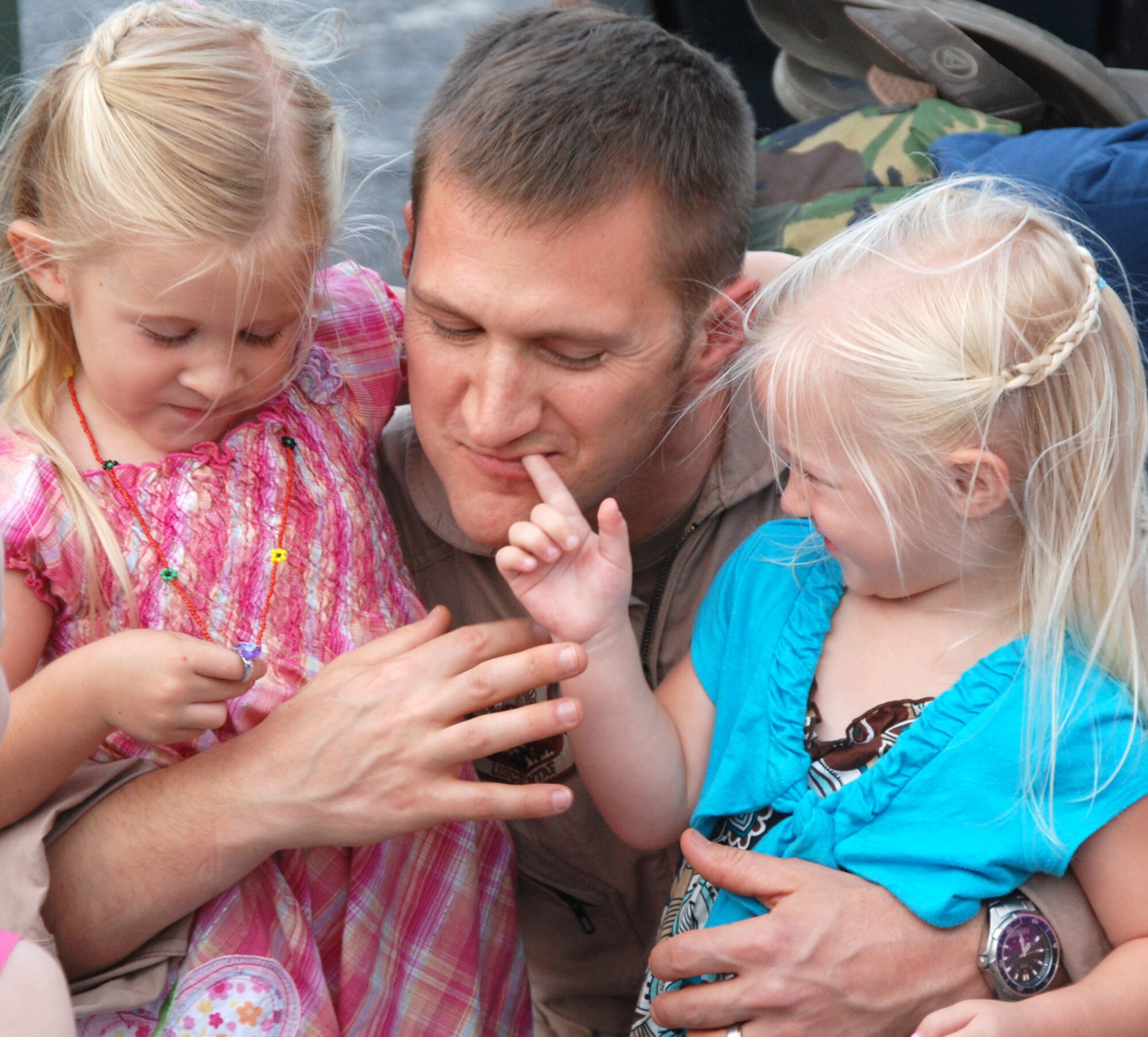 PATRICK AIR FORCE BASE, Fla. - This Airman hugging his two young daughters was among thirty of Brevard's Reserve Rescuers who returned home today from Afghanistan after four months of performing medical evacuation missions working with U.S. Army units.  These  Citizen Airmen conducted 2,000 medical evacuation missions flying HH-60 Pave Hawk helicopters loaded with aircrew and pararescuemen to save lives. More than half of these medical evacuations were due to combat action.  They helped saved more than 570 people and two military working dogs.  They provided life saving medical care to U.S. military members, coalition forces, as well as Afghani soldiers and citizens including 47 children and four enemy patients. (U.S. Air Force Photo/Capt. Cathleen Snow)