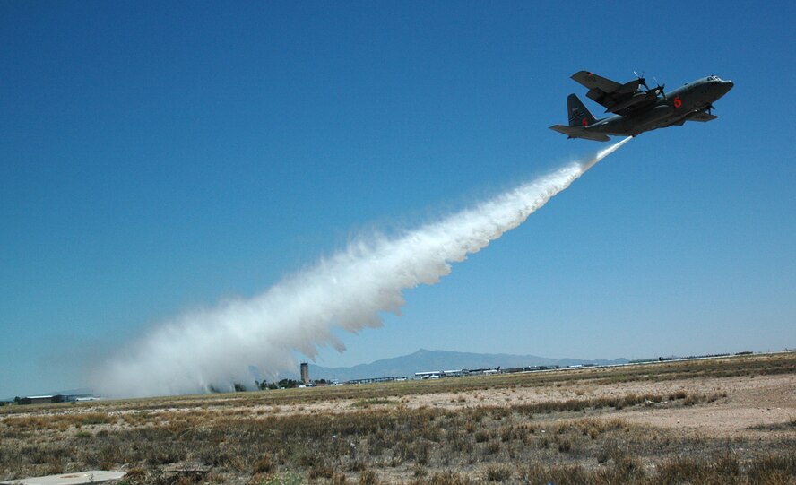 A C-130 Hercules with the Air Force Reserve's 302nd Airlift Wing drops its water load as members of the media look on May 6 at the Tucson International Airport in Arizona. Tucson was the location for the 2009 Military Airborne Firefighting System, or 'MAFFS' certification week, held May 3-9. Members of both the Air Force Reserve and Air National Guard certified on the MAFFS equipment and their C-130s, showcasing for U.S. Forest Service leadership and personnel their readiness in combating wildland fires nation-wide in the event Airmen are activated for the support. (U.S. Air Force photo/Capt. Jody Ritchie)