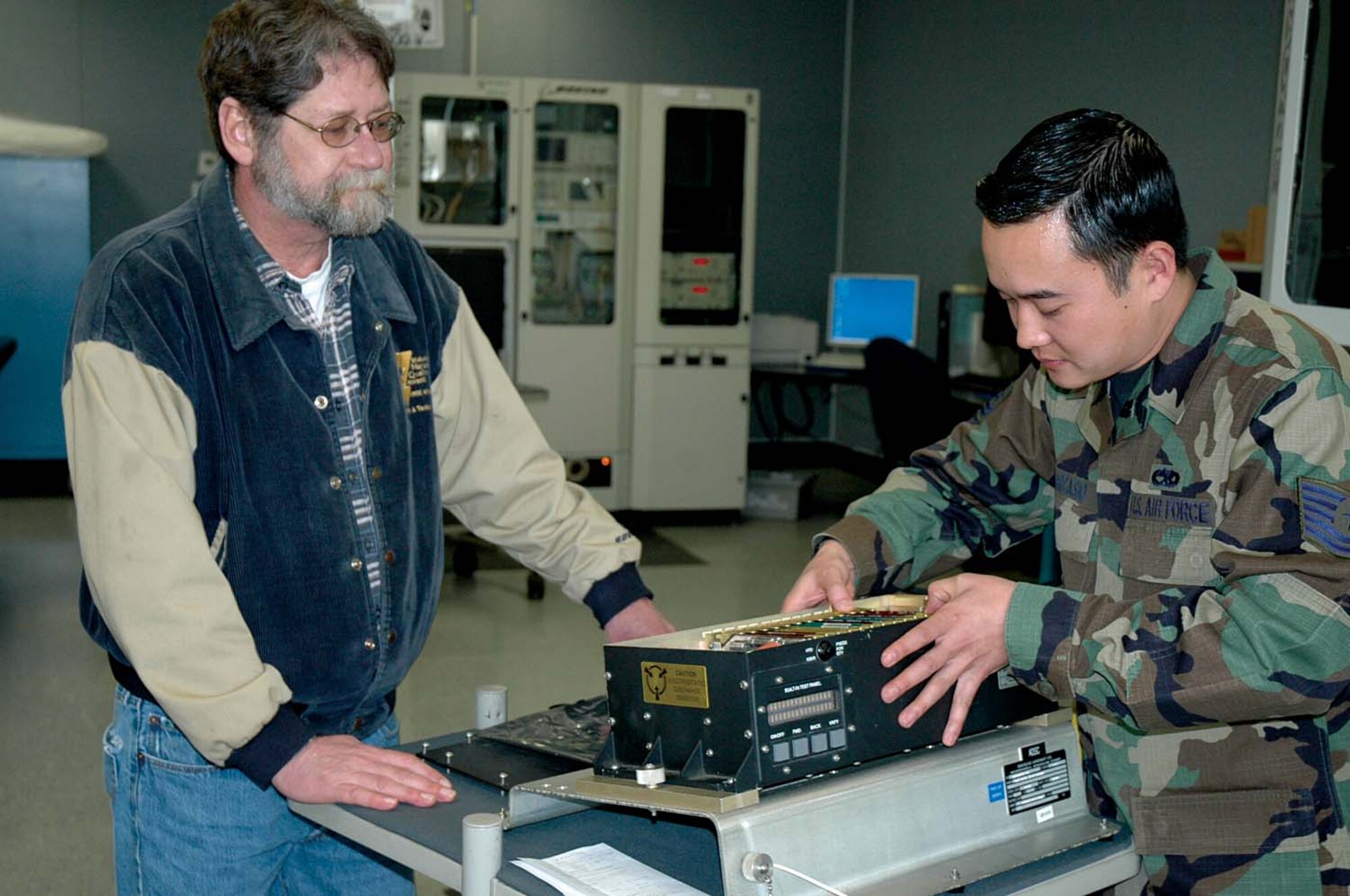 Larry Tellier and Tech. Sgt. Christopher Parcasio not only work as a team on avionics equipment, but they feed off each other's knowledge when developing suggestions for the Innovation Development Employee Award program.  Sergeant Parcasio is the Air Force's 2008 Exceptional Innovator of the Year, but credits much of his success to the support he receives from Mr. Tellier, a Boeing Company representative.  Sergeant Parcasio works in the 446th Maintenance Squadron, McChord Air Force Base, Wash. (U.S. Air Force photo/Sandra Pishner)