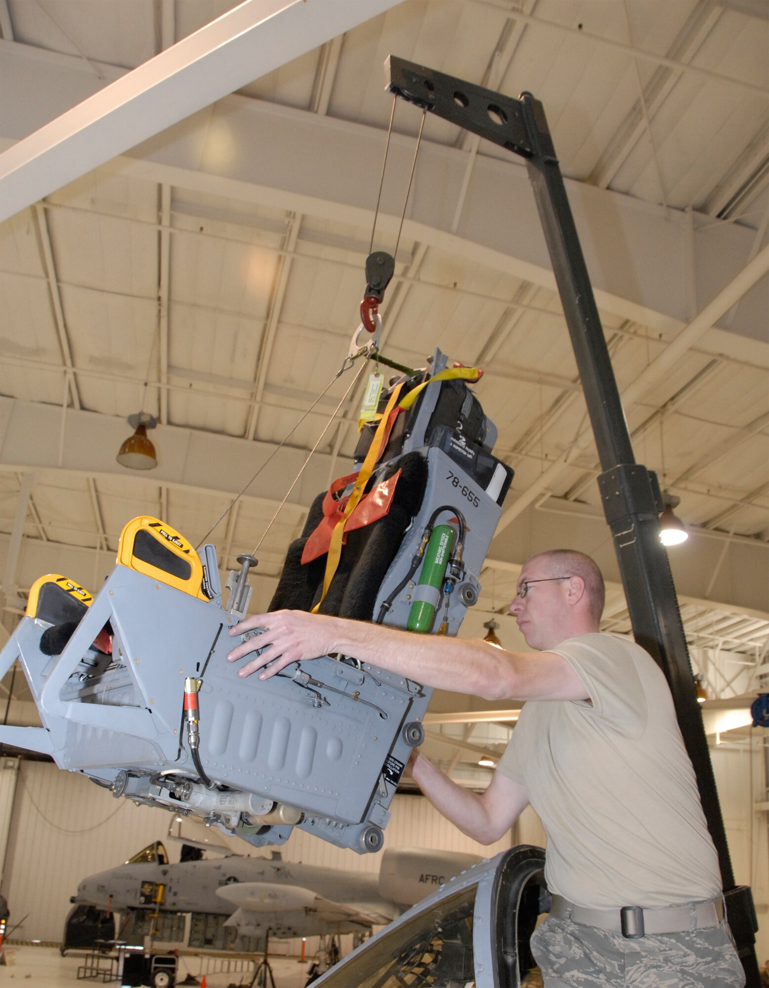 Staff Sgt. Anthony Bonham, an Air Force reservist with the 442nd Maintenance Squadron's Egress shop, carefully swings an ACES II ejection seat into position for installation into an A-10 Thunderbolt II, which belongs to the 442nd Fighter Wing at Whiteman Air Force Base, Mo. Sergeant Bonham and the other reservists in the Egress shop maintain the ejection seats to help ensure pilots have a way to safely and effectively leave the aircraft in the event of an emergency. (US Air Force photo/Master Sgt. Bill Huntington)