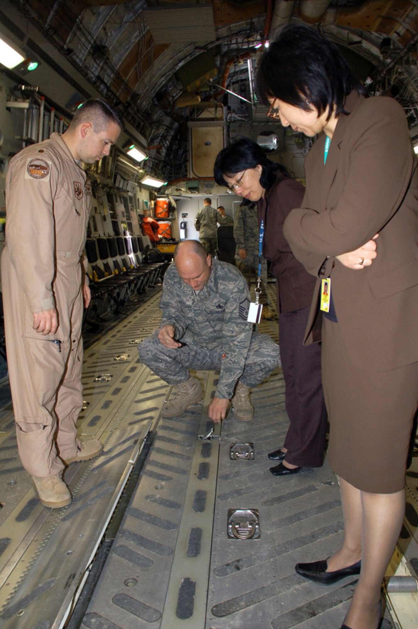 Maj. Glenn Donnelly (left) and Master Sgt. Edward Hood demonstrate to attendees of the recent 376th Expeditionary Medical Group's coalition medical symposium at Manas Air Base, Kyrgyzstan, how to configure the cargo bay of a C-17 Globemaster III to upload different types of palletized cargo.  Guests attending the symposium were from the Spanish coalition medical staff, U.S. Embassy medical unit, Peace Corps medical staff and the Bishkek Research Center of Trauma and Orthopedics.   Major Donnelly is deployed from Barksdale Air Force Base, La.  Sergeant Hood is deployed from Travis AFB, Calif. (U.S. Air Force photo/Tech. Sgt. Phyllis Hanson)