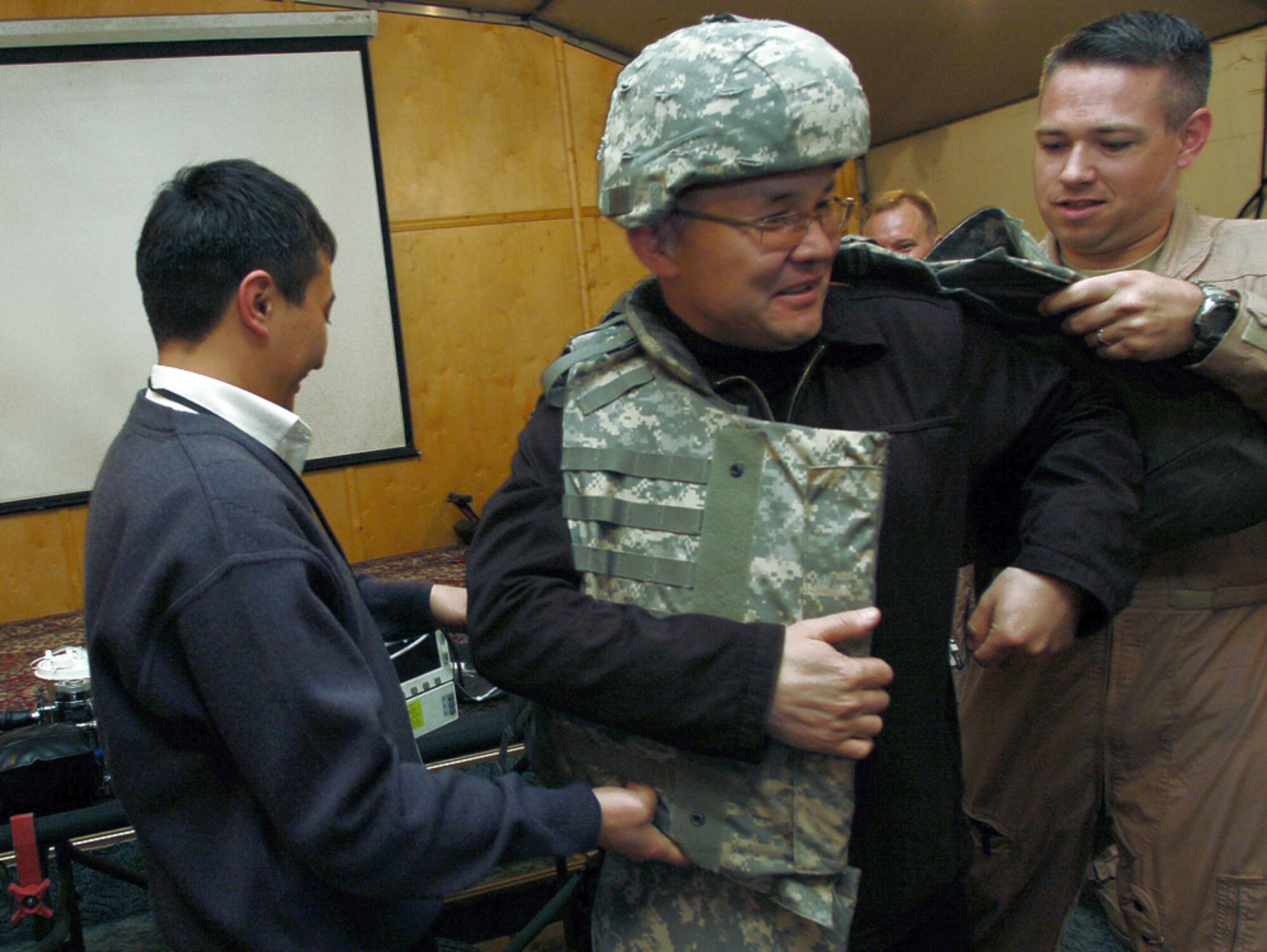 Maj. Glenn Donnelly helps a Kyrgyz guest try on body armor at Manas Air Base, Kyrgyzstan, during a recent coalition medical symposium hosted by the 376th Expeditionary Medical Group.  Guests attending the symposium were from the Spanish coalition medical staff, U.S. Embassy medical unit, Peace Corps medical staff and the Bishkek Research Center of Trauma and Orthopedics.   Major Donnelly is deployed from Barksdale Air Force Base, La.  . (U.S. Air Force photo/Tech. Sgt. Phyllis Hanson)