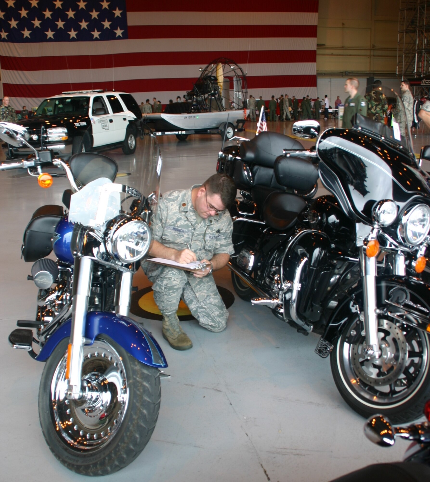 Maj. Dwight Minnick, commander, 552nd Maintenance Operations Squadron, pays close attention to detail as he judges the motorcycles at the Safety & Wellness Fair May 8.