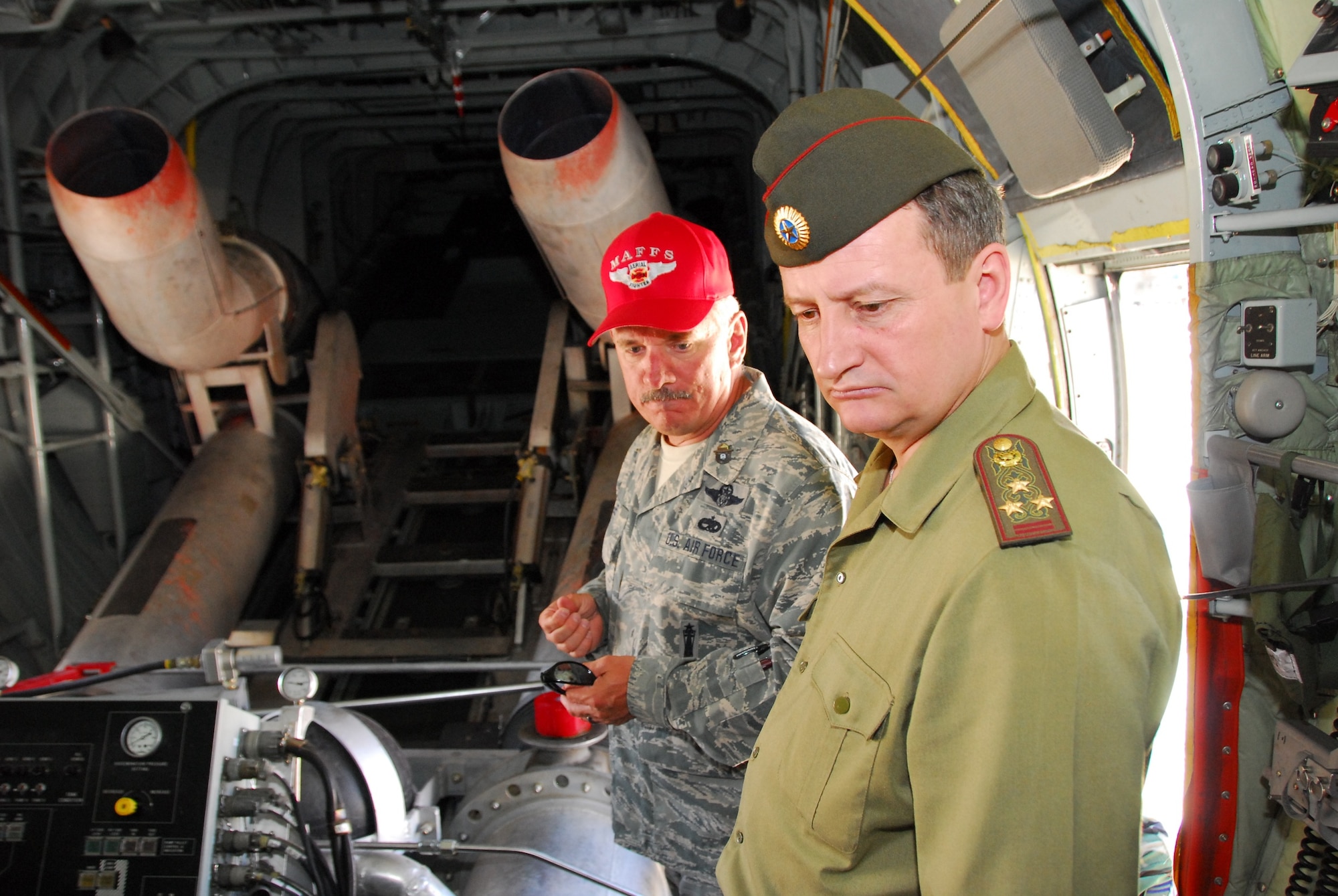 Chief Master Sgt. Chuck Lee from the 153rd Airlift Wing shows Col. Vladimir Bekker, deputy director of Kazakhstan’s firefighting service, the inside of a Wyoming Air National Guard C-130 equipped with the Modular Airborne Fire Fighting System, May 6. A Kazakh delegation from the Ministry of Emergency Situations observed the MAFFS training held in Tucson, Ariz., as part of the National Guard Bureau’s State Partnership Program. (Air National Guard photo by Master Sgt. Dave Neve)