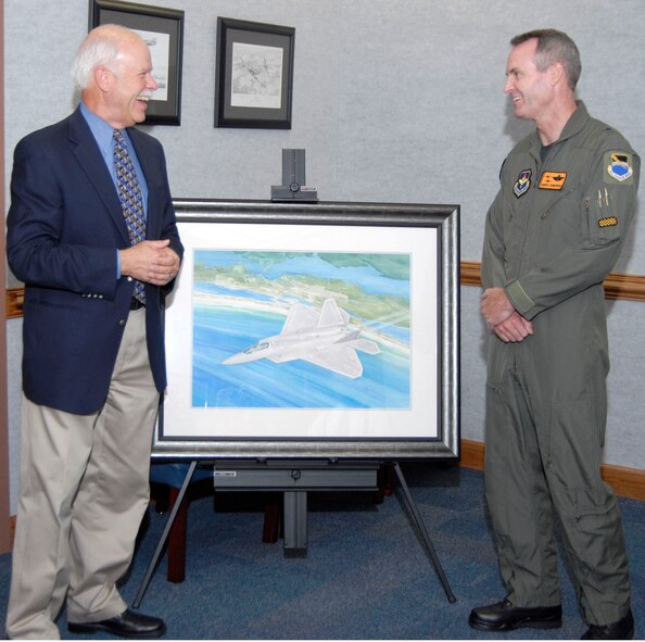 (Left) Paul Brent, a local Panama City, Fla., artist, shares a laugh with Brig. Gen. Darryl Roberson, 325th Fighter Wing commander, after Mr. Brent's painting "F-22 Raptor" is unveiled at Tyndall Air Force Base, Fla., May 8. The painting will hang outside of General Roberson's office in the 325 FW command section. Mr. Brent is often referred to worldwide as "America's best-known coastal artist." (U.S. Air Force photo/Robin Walters)