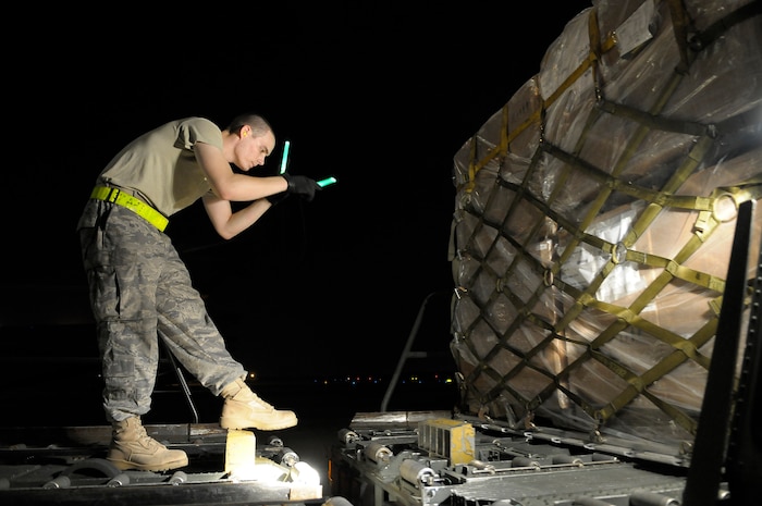 U.S. Air Force Airman 1st Class Daniel Anderson marshals a 60K loader of pallets with personal protection kits at Charleston Air Force Base, S.C., May 8, 2009. Thirty thousand personal protection kits were shipped to Haiti, El Salvador, Guatemala, Honduras and Nicaragua, where health-care officials are responding to confirmed and suspected cases of H1N1 Influenza-A infections. Each personal protection kit includes disposable respirators capable of screening 95 percent of particles as small as 0.3 microns, safety goggles, disposable overalls, gloves, shoe covers, and aprons, as well as infectious waste bags with biohazard symbols. Airmen Anderson is an air transportation specialist with the 437th Aerial Port Squadron at Charleston AFB. (U.S. Air Force photo by James M. Bowman)(RELEASED)