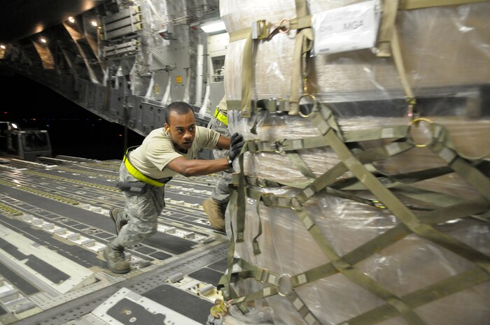 U.S. Air Force Airman 1st Class Marvin Richardson pushes a pallet of personal protection kits onto a C-17 at Charleston Air Force Base, S.C., May 8, 2009. Thirty thousand personal protection kits were shipped to Haiti, El Salvador, Guatemala, Honduras and Nicaragua, where health-care officials are responding to confirmed and suspected cases of H1N1 Influenza-A infections. U.S. Southern Command, headquartered in Miami, directed the mission after learning health officials submitted requests for assistance to U.S. embassies in their respective countries. This SOUTHCOM mission supports the ongoing international preparedness efforts of the U.S. government, led by the U.S. Agency for International Development. Airman Richardson is an air transportation specialist with the 437th Aerial Port Squadron at Charleston AFB. (U.S. Air Force photo by James M. Bowman) (RELEASED)