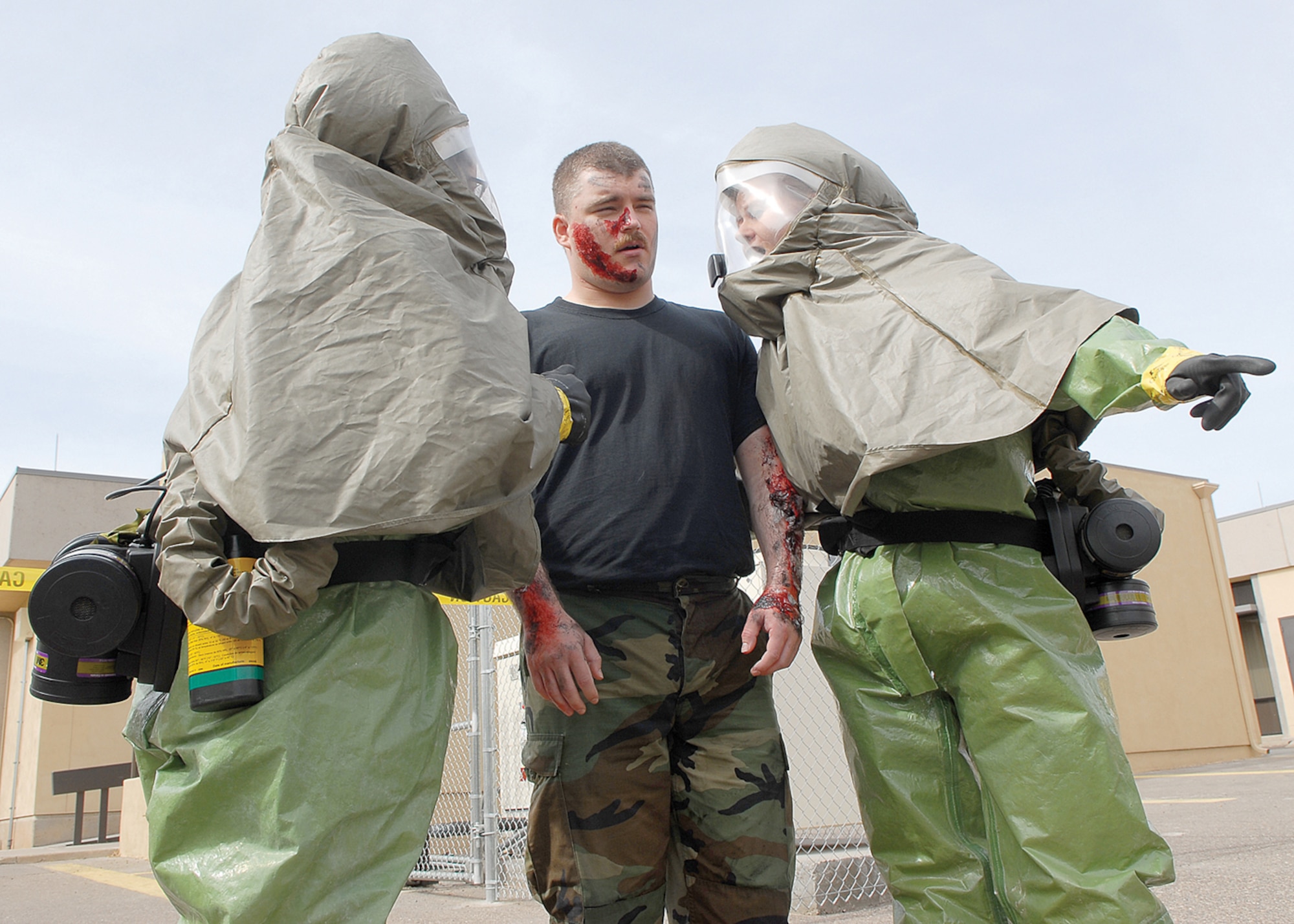 Staff Sgt. Adriane Alvarado, 56th Medical Operations Squadron medical technician, and 1st Lt. Chrystelle Williams, physician’s assistant, help simulated chemical burn victim Senior Airman John Matthews, 56th Operations Support Squadron intel element leader, seek immediate attention during a major accident response exercise on the east side of the 56th Medical Group building on Tuesday. Patients exposed to chemicals must be decontaminated before entering the building to prevent further contamination of medical staff and other patients. For more images, see page 16. (U.S. Air Force photo/ Airman 1st Class Ronifel Yasay)