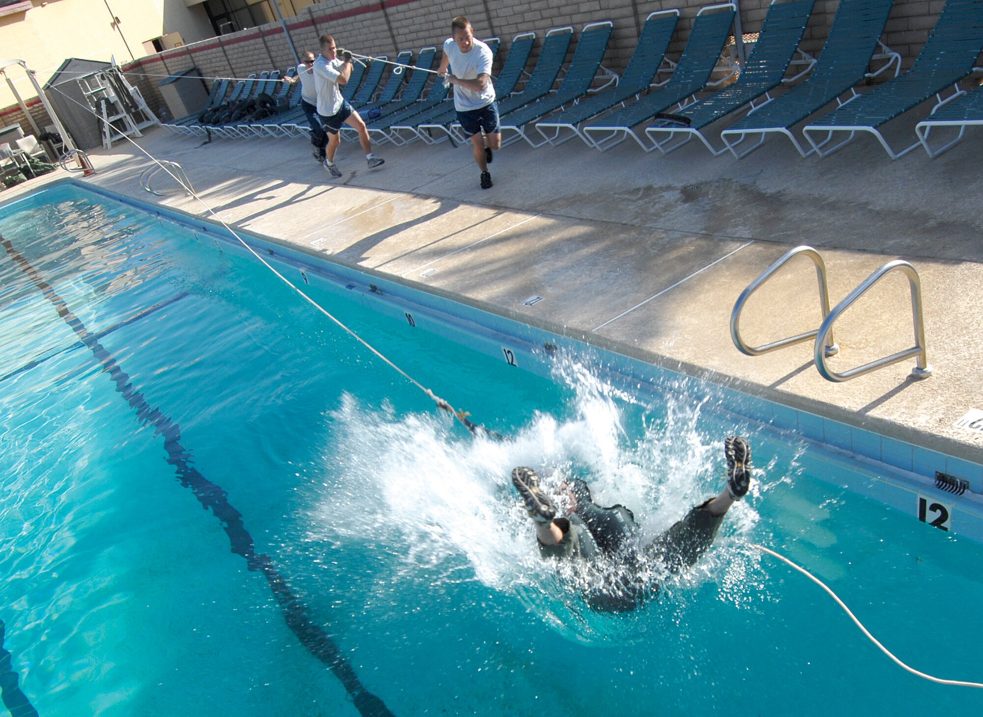 Col. Hank Reed, 56th Fighter Wing vice commander, gets yanked backwards into the Silver Wings Pool by members of the Aircrew Flight Equipment Flight as part of water survival refresher training. The move is designed to simulate a pilot being drug by his own canopy after ejection from an aircraft. (U.S. Air Force photo/Tech. Sgt. Jeffery Wolfe)