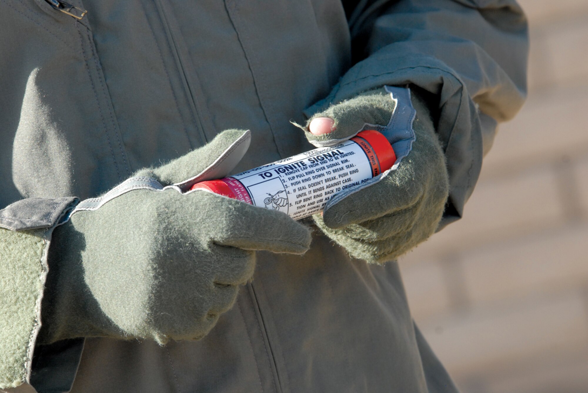 Capt. Matt Spears, 309th Fighter Squadron instructor pilot, examines a day flare before “popping” it during a water survival training course at Silver Wings Pool. (U.S. Air Force photo/ Deborah Silliman Wolfe)