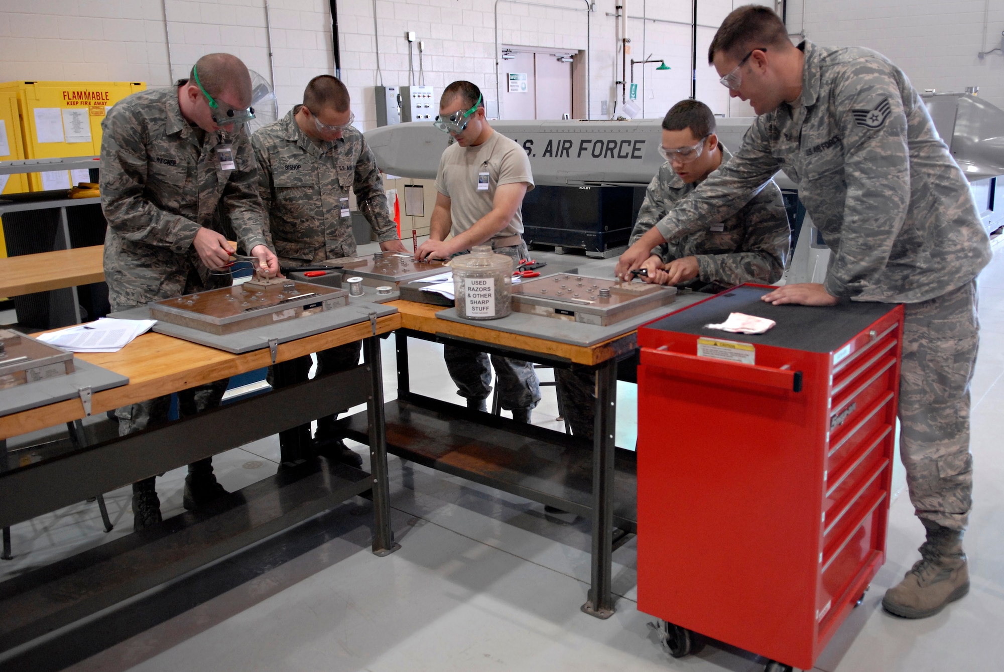 VANDENBERG AIR FORCE BASE, Calif. -- Staff Sgt. Steven Zimmer, a 532nd Training Squadron air launch missile maintenance instructor, helps 532nd TRS students learn how to create a safety wire here May 4. Several items, such as bolts on a missile, must be safety-wired in place to prevent the parts from shaking loose during flight. Sergeant Zimmer has been an instructor for a year. (U.S. Air Force photo/Senior Airman Christian Thomas)