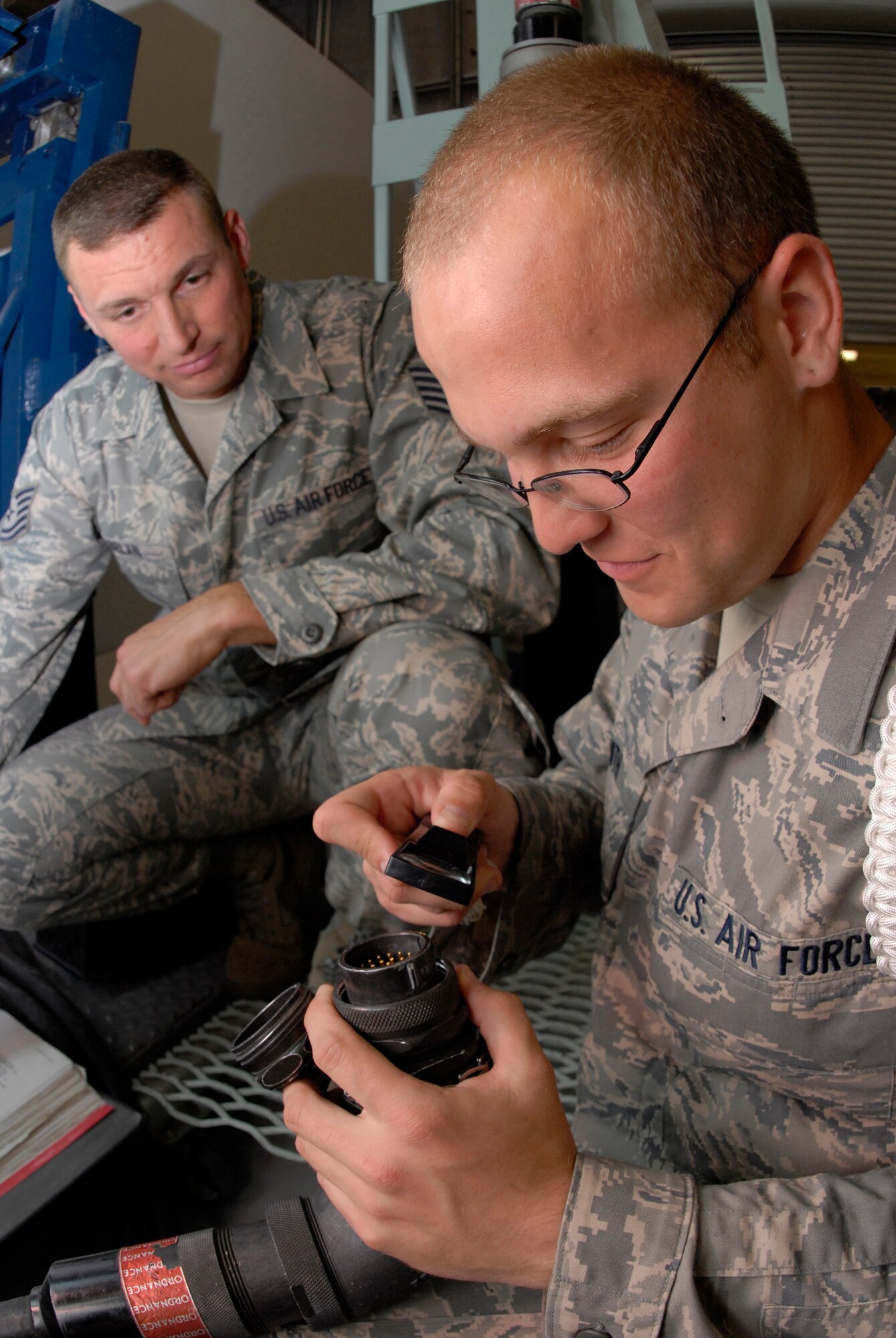 VANDENBERG AIR FORCE BASE, Calif. -- Airman Basic David Smith, a 532nd Training Squadron student, inspects W950 ordnance cable for damage as Tech. Sgt. Brian Belan, a 532nd Training Squadron missile and space systems maintenance instructor, watches for mistakes here May 6. The course includes a missile and space systems overview, code handling procedures, technical publications, maintenance forms, tools, corrosion, security, environmental compliance, hazardous communication, maintenance principles, practices and management. Sergeant Belan has been an instructor for three years. (U.S. Air Force photo/Senior Airman Christian Thomas)