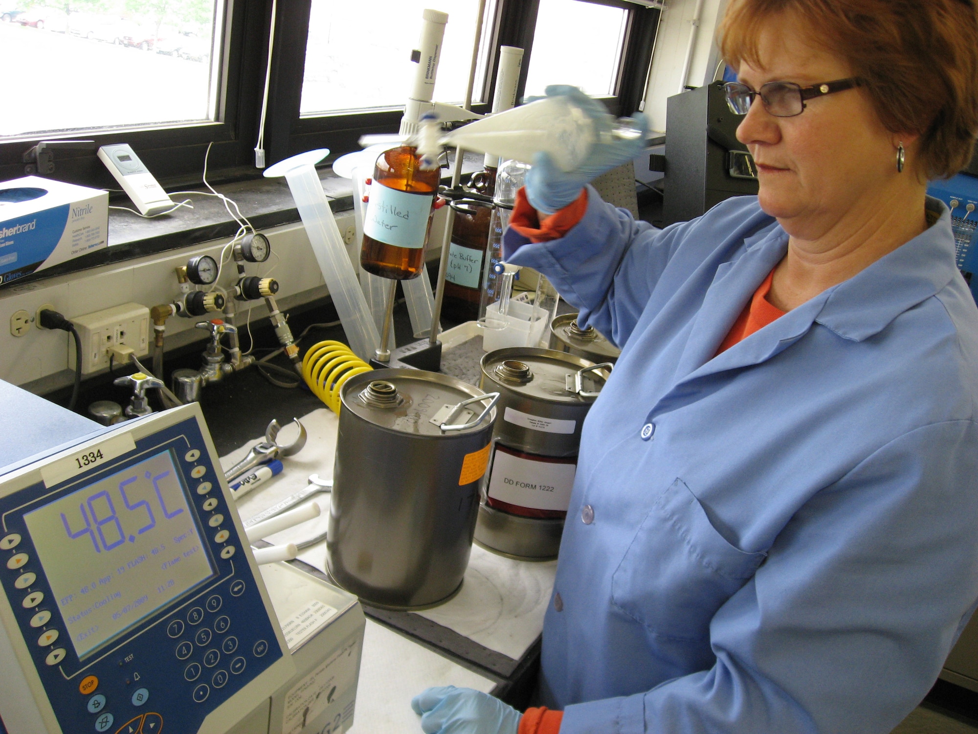 Janet Stewart concludes a test of the flash point temperature in a sample of commercial Jet A fuel while preparing to measure the concentration of fuel system icing inhibitor in another sample in the Aerospace Fuels Laboratory at Wright-Patterson Air Force Base, Ohio. Air Force Petroleum Agency and Air Force Research Laboratory researchers are partnering on an initiative to evaluate the use of commercial jet fuel in place of military standard JP-8 fuel. Ms. Stewart is a fuels quality assurance specialist with the Aerospace Fuels Laboratory at Wright-Patterson AFB. (U.S. Air Force photo/Derek Kaufman)