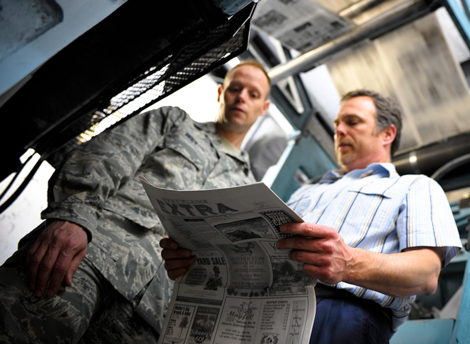 Col. Blaine Holt, 92nd Air Refueling Wing vice commander, and Harland Shellabarger, Cheney Free Press Publisher, look over a newspaper example as they discuss Fairchild’s upcoming news service May 4. During the visit, Colonel Holt reflected on his time as a news press operator while finishing his high school education. (U.S. Air Force photo / Senior Airman Joshua K. Chapman) 