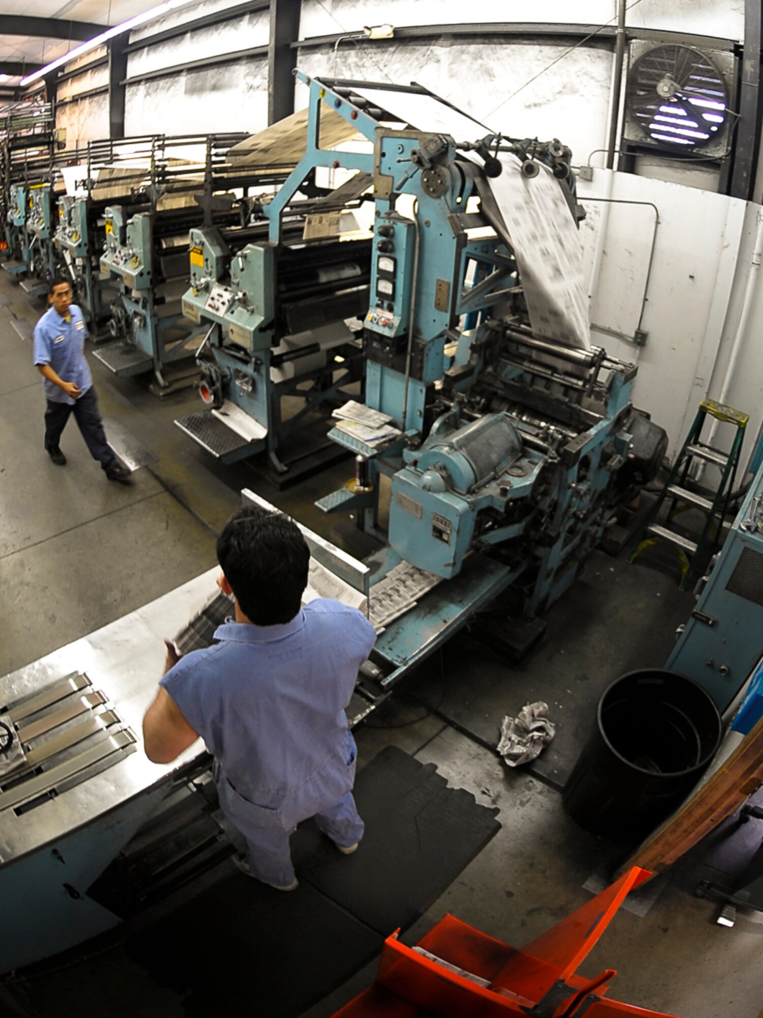Sergio Reynaga, an operator with the Cheney Free Press, and Randy Warwick, a press foreman with the company, work quickly putting together a newspaper May 4. Reynaga has been with the company for six years; Warwick has worked with the company for 33 years. (U.S. Air Force photo / Senior Airman Joshua K. Chapman)