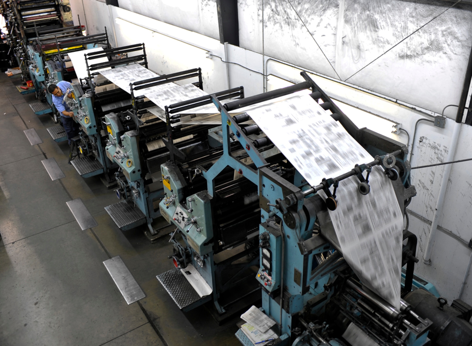 A printing press speeds through hundreds of sheets at the Cheney Free Press main office May 4. Before delivery, papers are individually folded and organized by Cheney Free Press employees. (U.S. Air Force photo / Airman 1st Class Melissa L. Barnett)