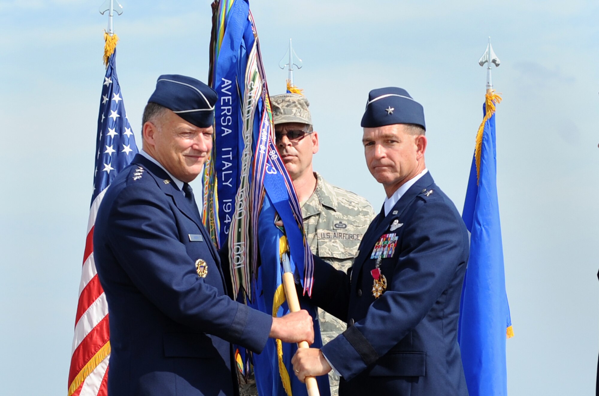 LANGLEY AIR FORCE BASE, Va. -- Brig. Gen. Mark A. Barrett relinquishes command of the 1st Fighter Wing by handing the guidon to Lt. Gen. Gary L. North, commander of the 9th Air Force and U.S. Air Forces Central, during the change of command ceremony here May 8. Colonel Matthew H. Molloy assumed command from General Barrett. (U.S. Air Force photo/Airman 1st Class Gul Crockett)  