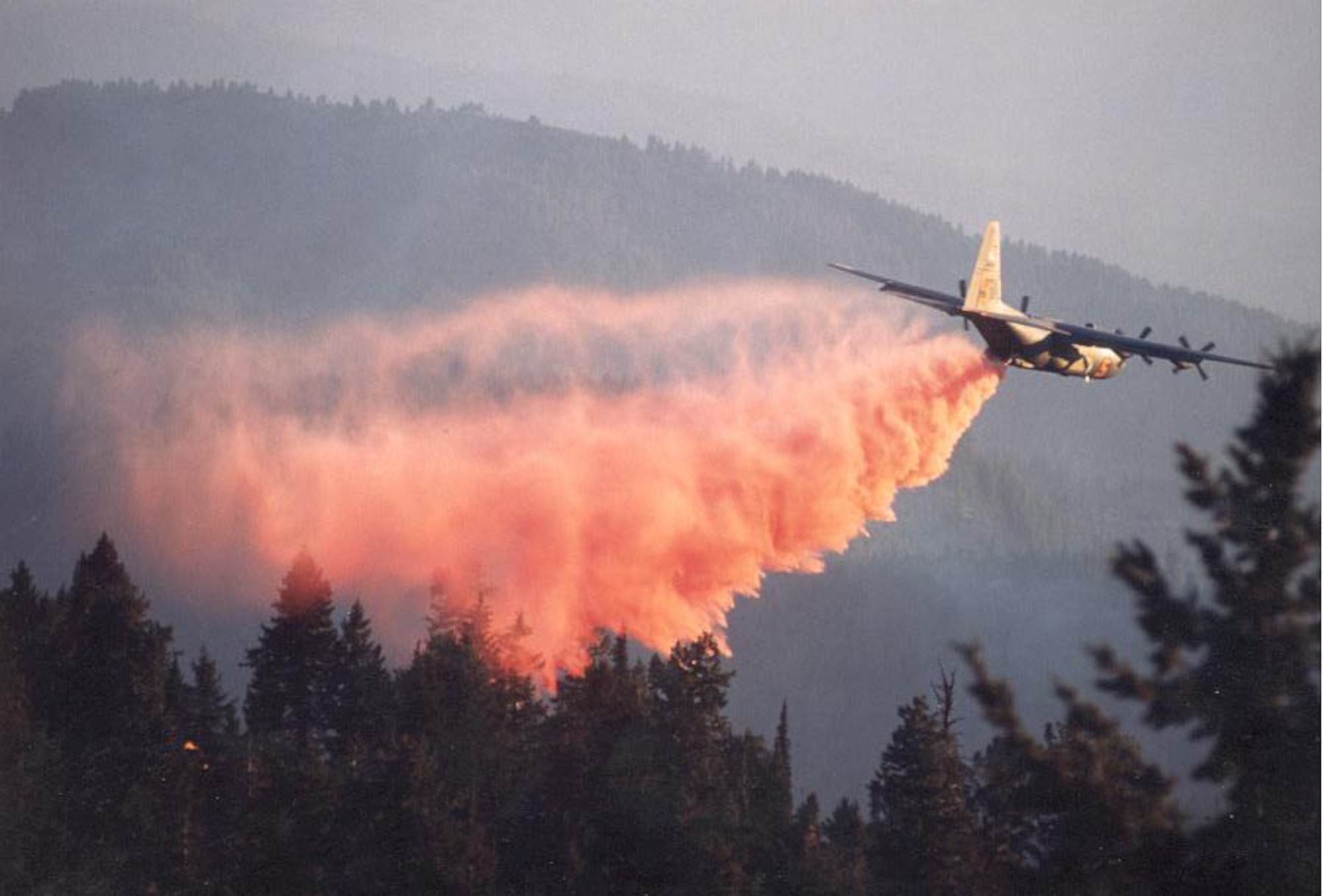 A C-130 uses aerial firefighting equipment known as the Modular Airborne Fire Fighting System to drop red-colored retardant, or ‘slurry’ as it is sometimes called, from the plane into the air over a fire. MAFFS was established by Congress in the early 1970s to create a national response system to better fight major fires. (U.S. Air Force Photo)