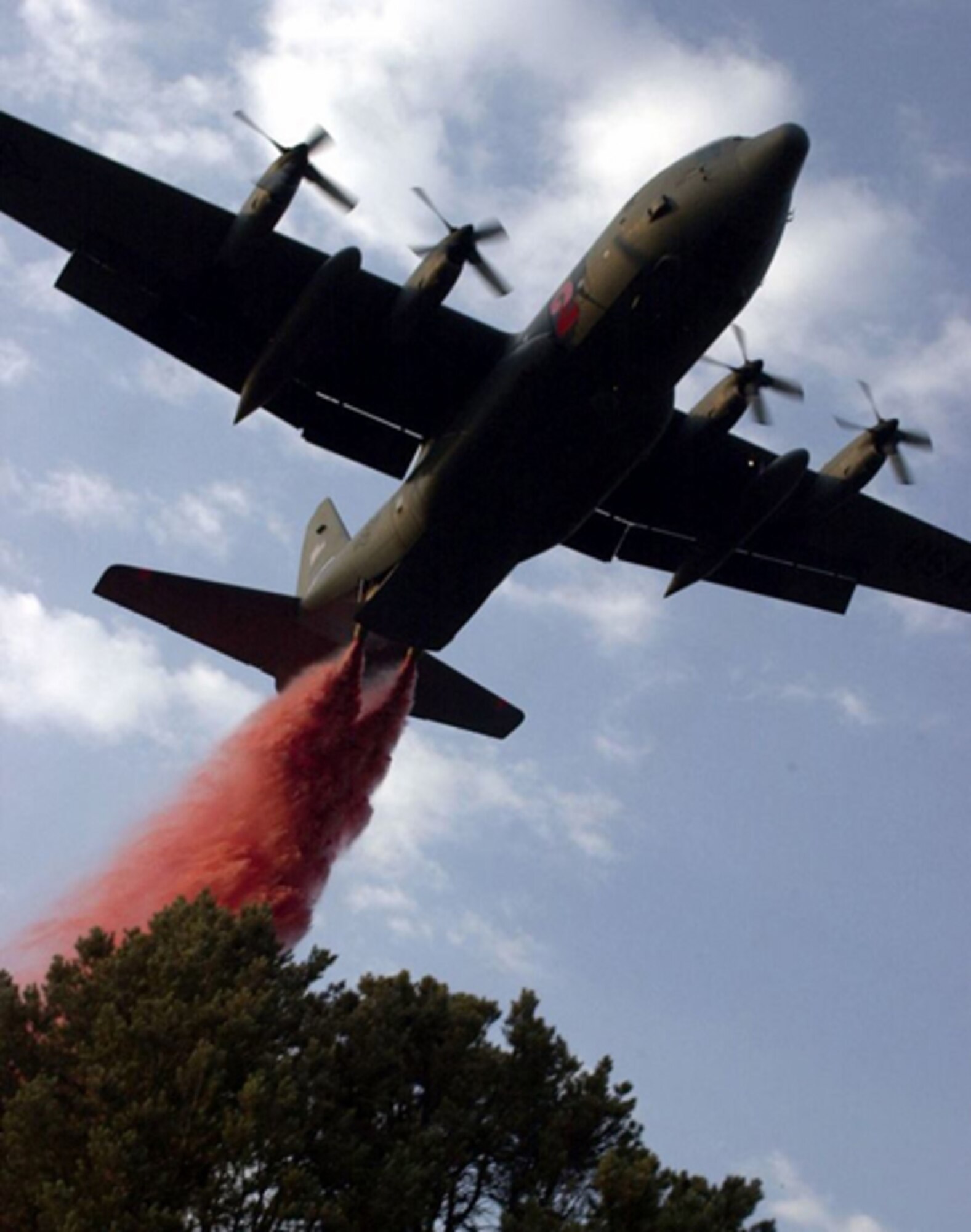 A C-130 uses aerial firefighting equipment known as the Modular Airborne Fire Fighting System to drop red-colored retardant, or ‘slurry’ as it is sometimes called, from the plane into the air over a fire. MAFFS was established by Congress in the early 1970s to create a national response system to better fight major fires. (U.S. Air Force Photo)
