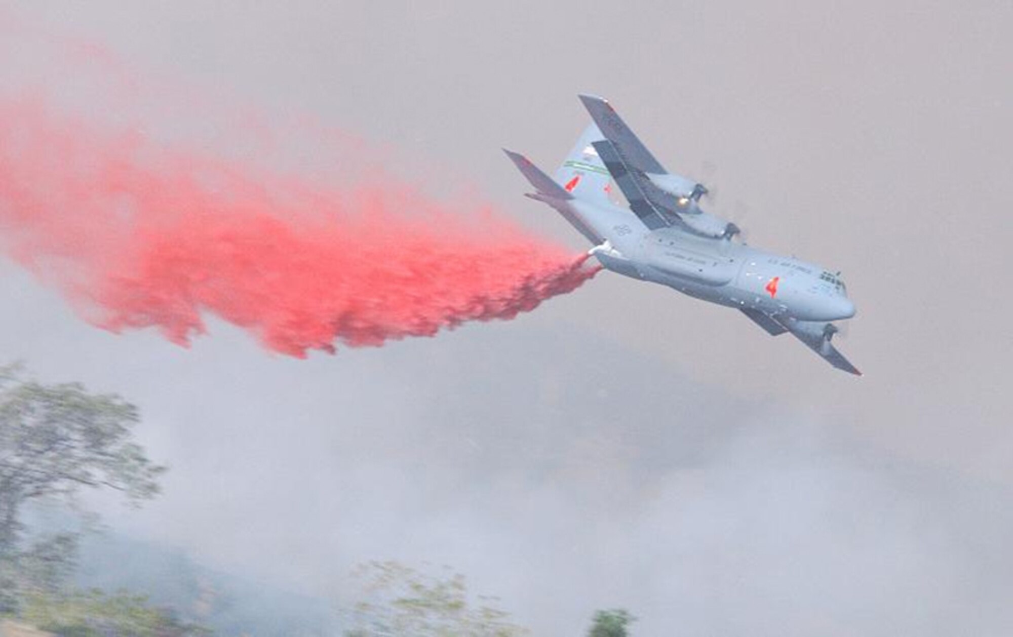 A C-130 uses aerial firefighting equipment known as the Modular Airborne Fire Fighting System to drop red-colored retardant, or ‘slurry’ as it is sometimes called, from the plane into the air over a fire. MAFFS was established by Congress in the early 1970s to create a national response system to better fight major fires. (U.S. Air Force Photo)