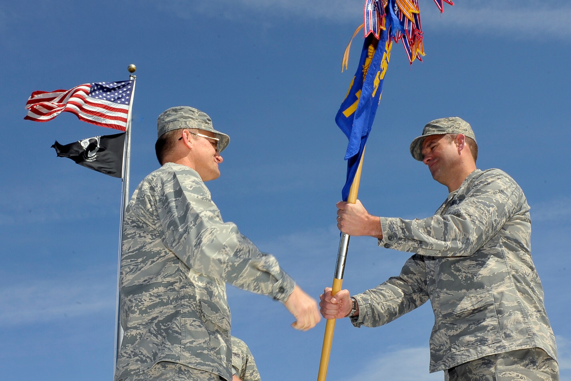 The 66th Training Squadron guidon is passed off to Lt. Col. Christopher C. Tacheny, incoming 66th Training Squadron commander, during the Change of Command Ceremony on the Survival, Evasion, Resistance and Escape headquarters building May 1. During the ceremony the colonel remarked on his hope and pride of becoming the 66th TRS commander. (U.S. Air Force photo / Senior Airman Joshua K. Chapman)