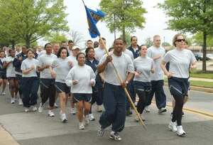 Master Sgt. Reginald Simms, center with guidon, 316th Force Support Squadron chief of the logistics support section, and Lt. Col. Teresa Forest, 316 FSS commander, right, lead their squadron during a two-mile base Fit Run, hosted by the 316th Wing, May 1.  (U.S. Air Force photo/ Bobby Jones)
