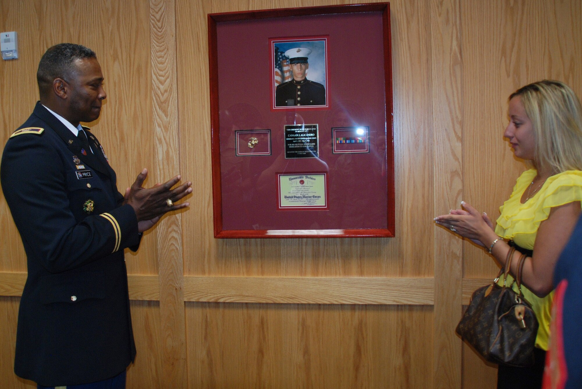 Melissa B. Chapin and Col. Barrye Price unveil a memorial for Chapin's husband, Marine Sgt. Canaan Alicandro, May 7 at the Military Entrance Processing Station at Westover. Colonel Price, commander of the Easterm Sector, United States Military Entrance Command, joined Lt. Cdr. Johnny Bowen, MEPS commander, and Sergeant Alicandro's family, for the dedication of the MEPS ceremony room to the fallen Marine. Sergeant Alecandro took the oath of enlistment at the MEPS in 2000, when it was located in Springfield. The Marine died in a car accident while stationed at Camp Lejeune, N.C. (US Air Force photo/Tech. Sgt. Andrew Biscoe)