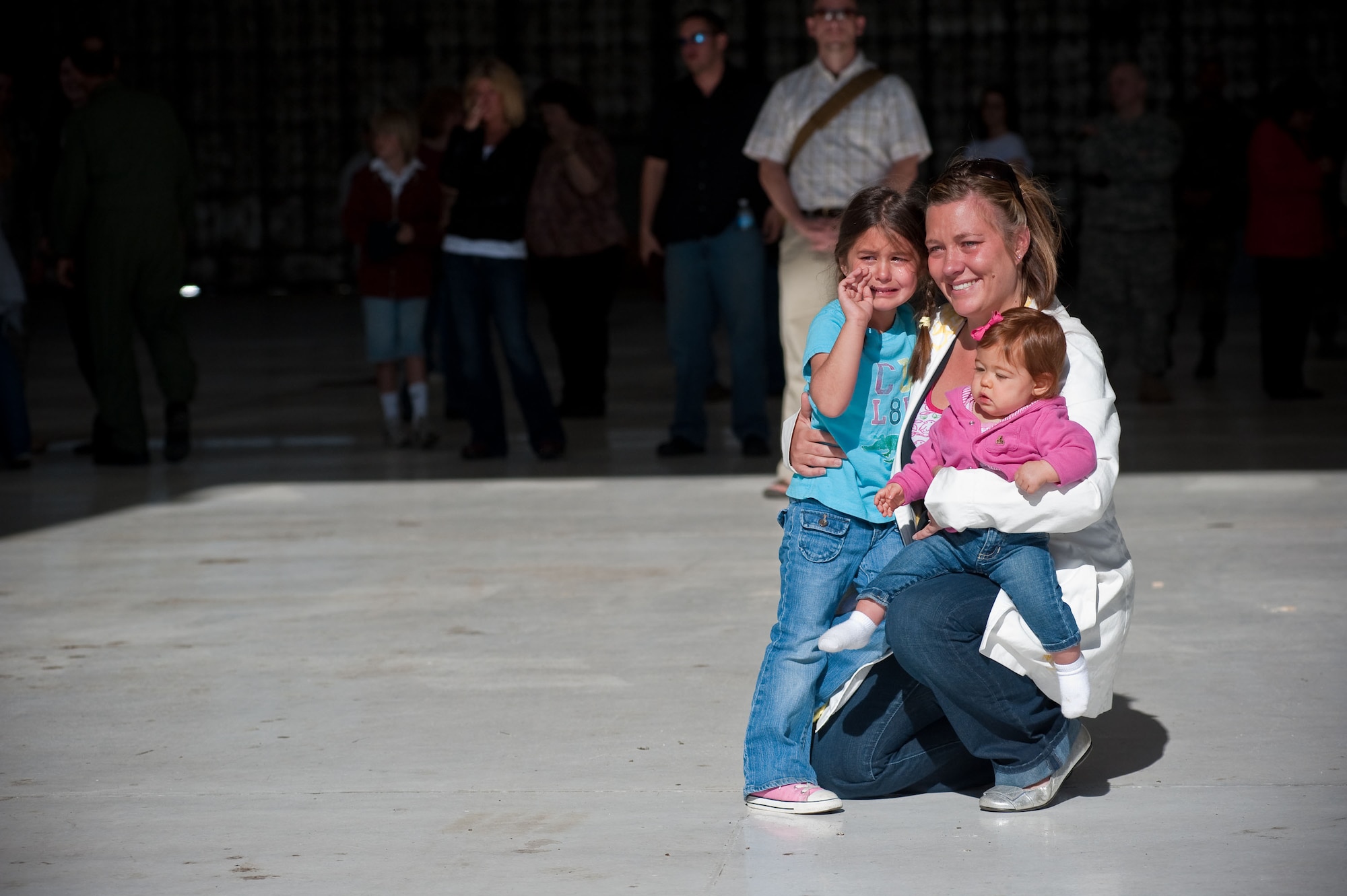 Jamie holds daughters Ava and Izabel as they watch husband and father Technical Sgt. Paul Porras depart for his deployment to Iraq. TSgt. Porras, 140th Maintenance Squadron, Colorado Air National Guard, Buckley Air Force Base, Aurora, CO, is deploying to Iraq in support of Operation Iraqi Freedom along with more than 200 other Airman from the base. (U.S. Air Force photo/Master Sgt. John Nimmo, Sr.) (RELEASED)