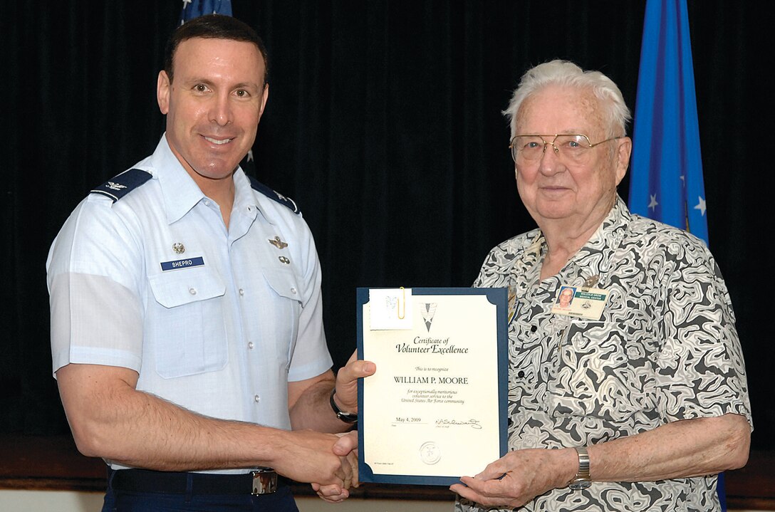 Colonel Steven Shepro, 316th Wing commander, presents a certificate of volunteer excellence to William P. Moore at the Community Activities Center Monday. Mr. Moore has a long history of dedicated service to the community of Andrews and  was awarded for most volunteer hours. The volunteer awards are based on the total amount of hours each individual or teams has contributed to improve the services and quality of life on Andrews. (U.S. Air Force photo/ Senior Airman Giang Nguyen)
