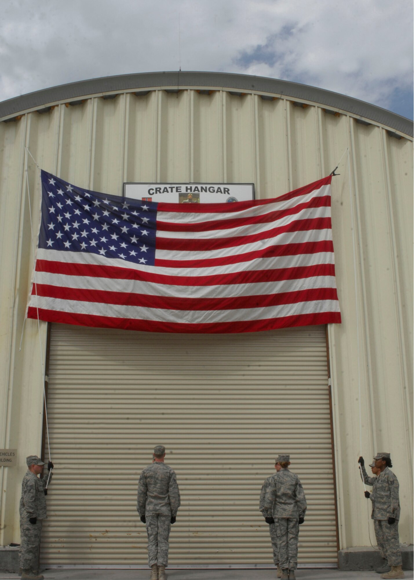 Members of the 1st Special Operations Maintenance Squadron, lower the flag at a building dedication ceremony for Staff Sgt. Casey Crate at Bagram Air Field, Afghanistan, May 1. The flag was folded and presented to Lt. Col. Brett Nelson, 23rd Special Tactics Squadron commander and will be flown back to the United States and presented to Sergeant Crate's mother. (U.S. Air Force photo/ Senior Airman Erik Cardenas)(Released)

