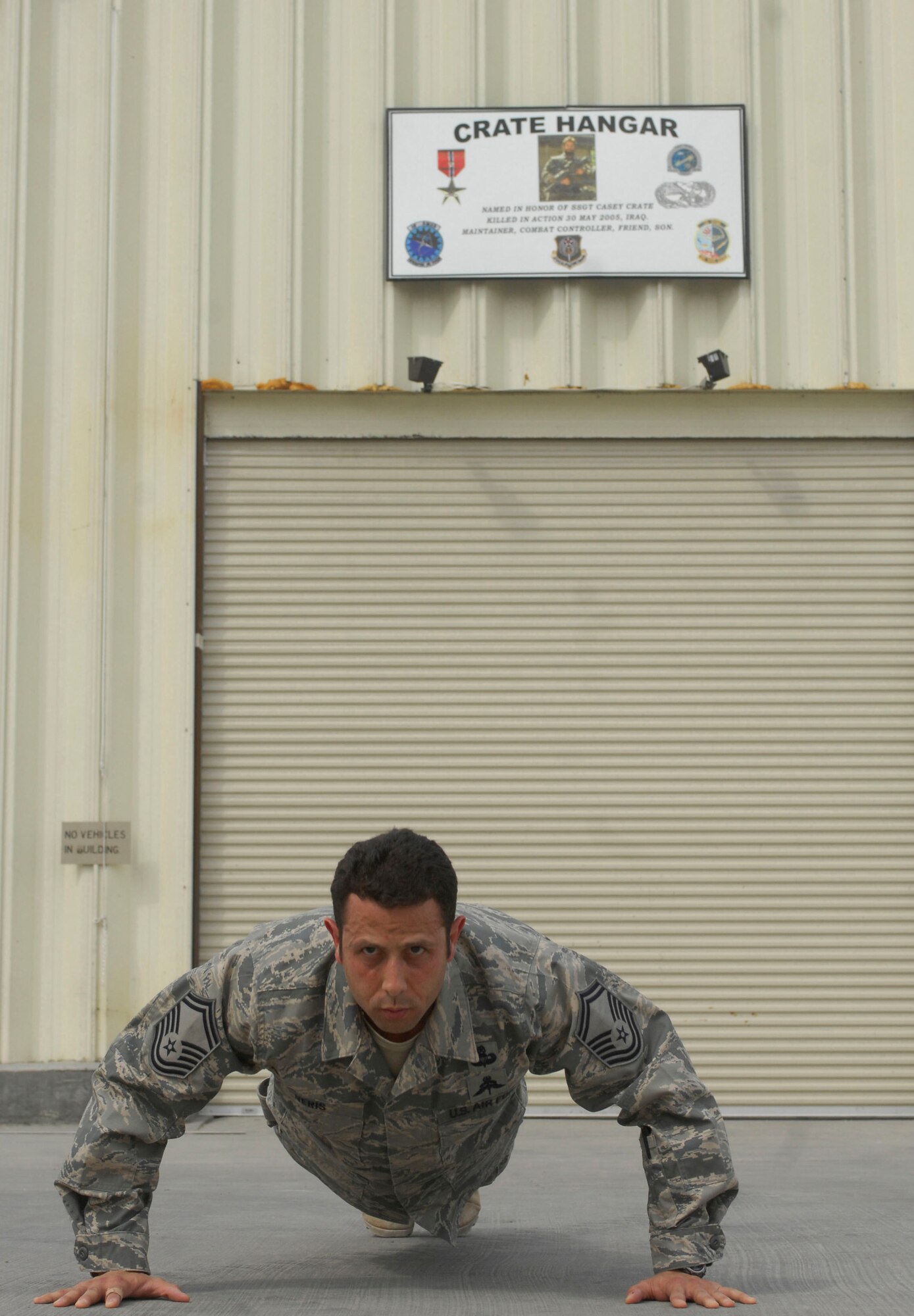 Senior Master Sgt. Carlos Neris, 23rd Expeditionary Special Tactics Squadron, does push-ups for his fallen comrade during the building dedication ceremony for Staff Sgt. Casey Crate at Bagram Air Field, Afghanistan, May 1. Sergeant Crate was killed in a aircraft crash May 30, 2005, in central Iraq. It is customary for special tactics Airmen to do push-ups for their fellow special operators. The unit performed 10 memorial four-count push-ups, then one for SSgt Casey Crate, one for other fallen comrades, and one for team. Sergeant Neris is deployed from Hurlburt Field, Fla. (U.S. Air Force photo/ Senior Airman Erik Cardenas)(Released)