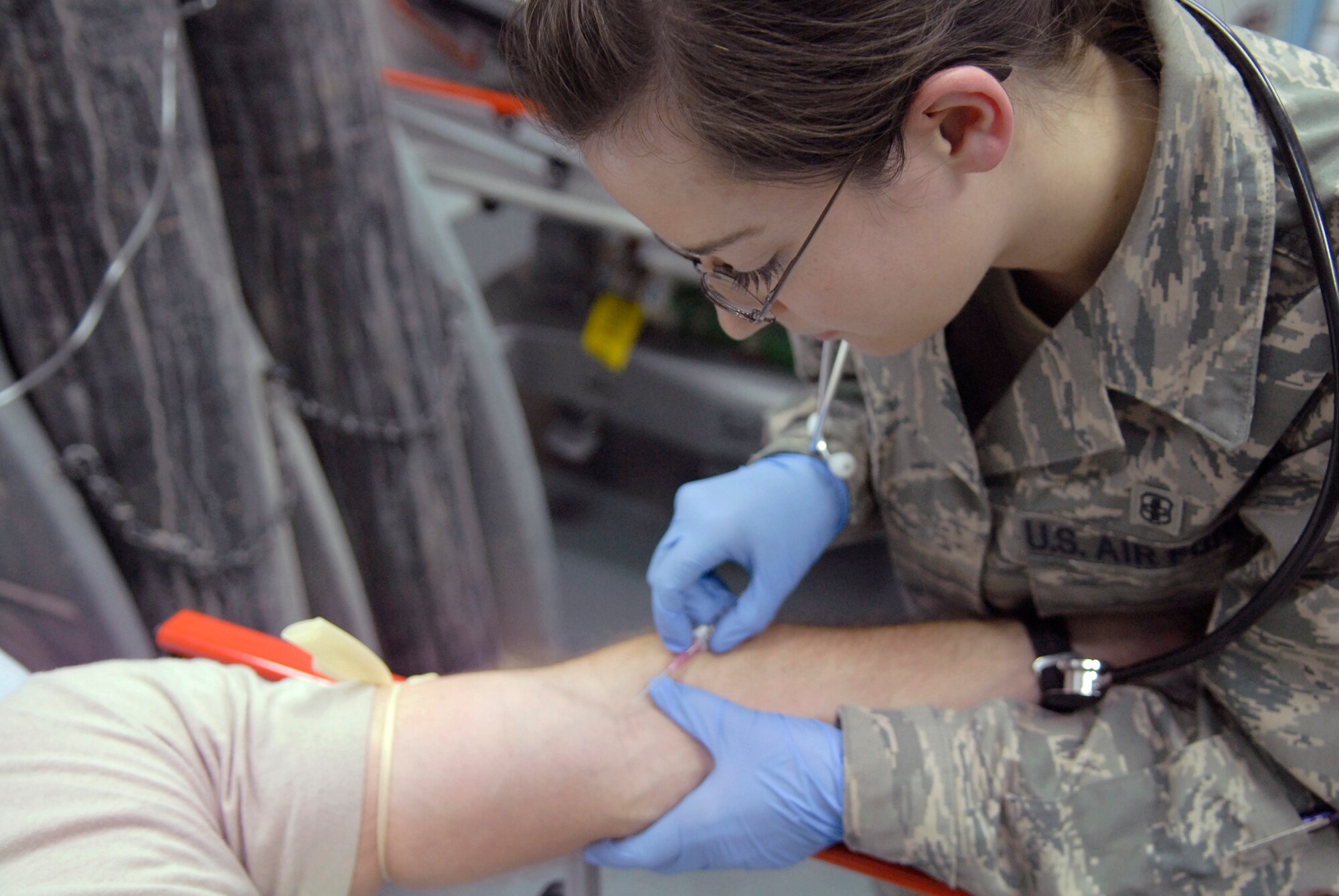 Senior Airman Marlena Pagliuca, 379th Expeditionary Medical Group medical technician, prepares to insert an18 gauge intravenous catheter into a patient, May 6, 2009, at an undisclosed location in Southwest Asia.  The med techs are first responders who provide basic medical care for patients by checking vitals and performing an initial assessment of their patients.  Airman Pagliuca hails from Rockland, Mass. and is deployed from Keesler Air Force Base, Miss., in support of Operations Iraqi and Enduring Freedom and Combined Joint Task Force - Horn of Africa.  (U.S. Air Force photo/Senior Airman Andrew Satran/released)  