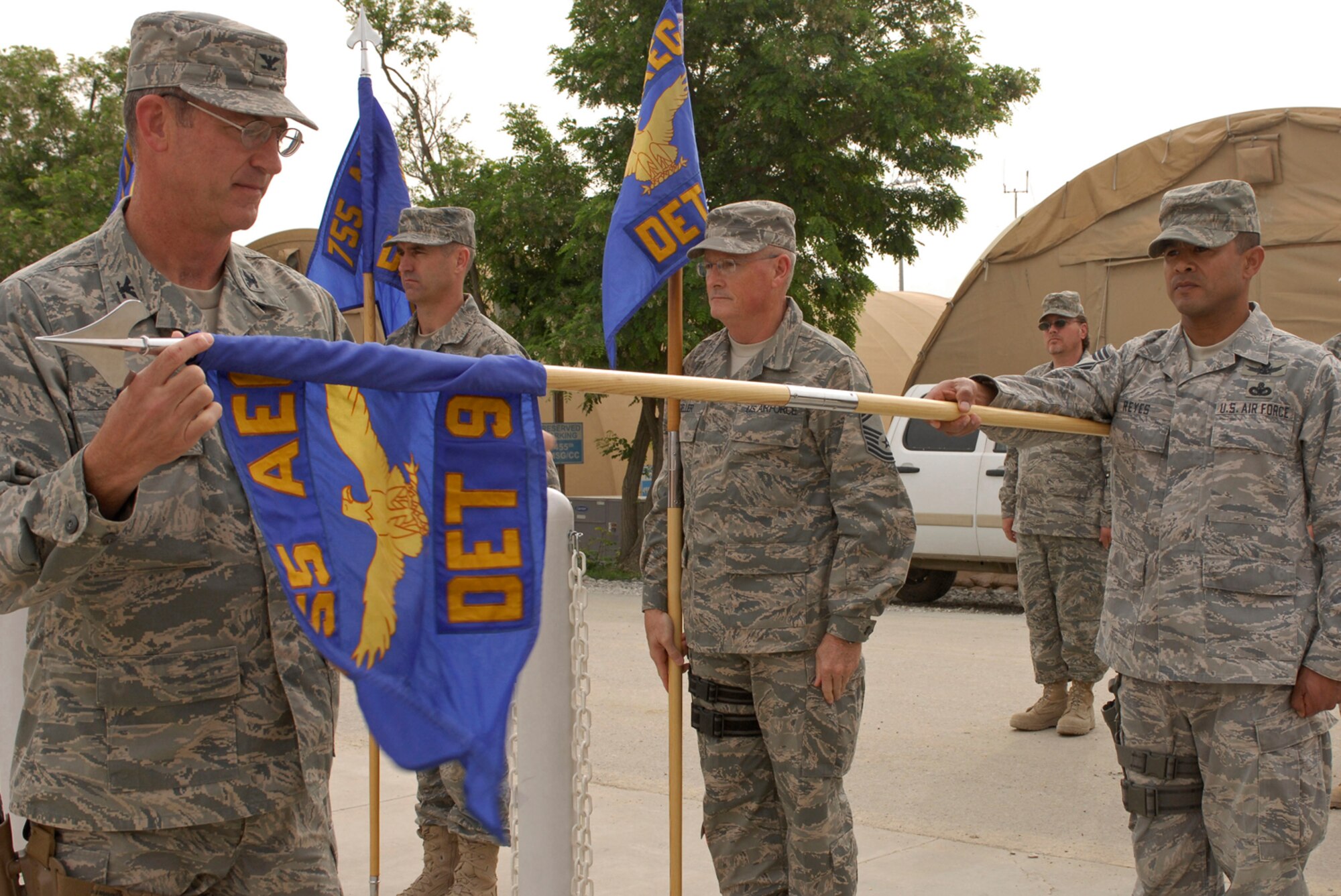 Col. James Reed, 755th Air Expeditionary Group commander, unfurls the 955th Air Expeditionary Squadron guidon flag as Chief Master Sgt. Rodney Reyes, 955th AES superintendent, during an assumption of command ceremony at Bagram Air Field, Afghanistan, May 5. The squadrons were stood up to provide better accountability and support for more than 1,200 Joint Expeditionary Tasking and Individual Augmentee Airmen scattered throughout Afghanistan's more than 40 forward operating bases and camps. (U.S. Air Force photo/ Senior Airman Erik Cardenas)(Released)