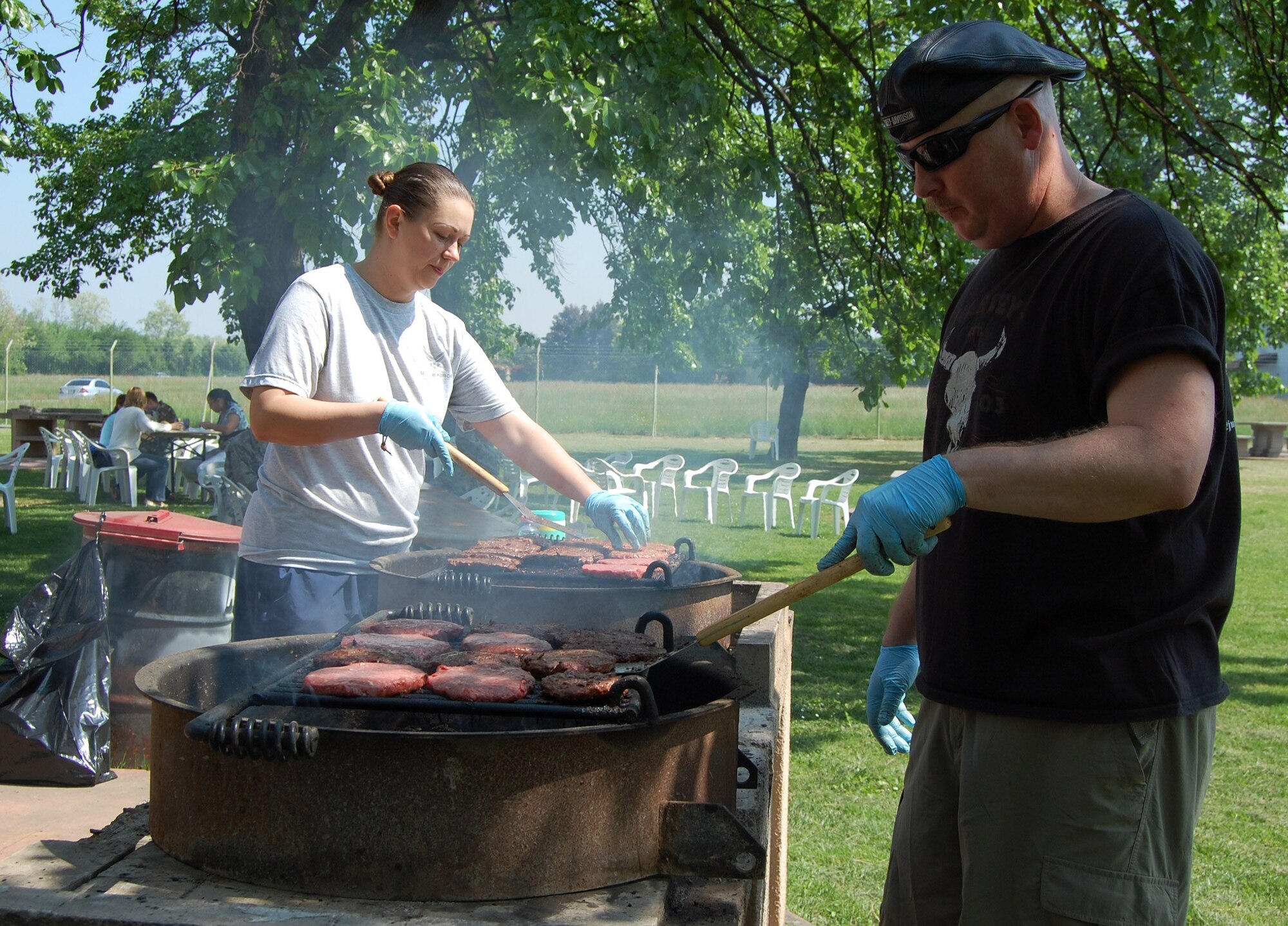 Master Sgt. Melissa Merritt and Chief Master Sgt. Daryl Webb of the 31st Medical Group grill burgers to serve to base volunteers as part of the annual Aviano Volunteer Recognition Ceremony May 7, 2009 in Area D. Volunteers donated more than 22,225 hours of time last year to the local community. (U.S. Air Force photo/Staff Sgt. Lindsey Maurice)
