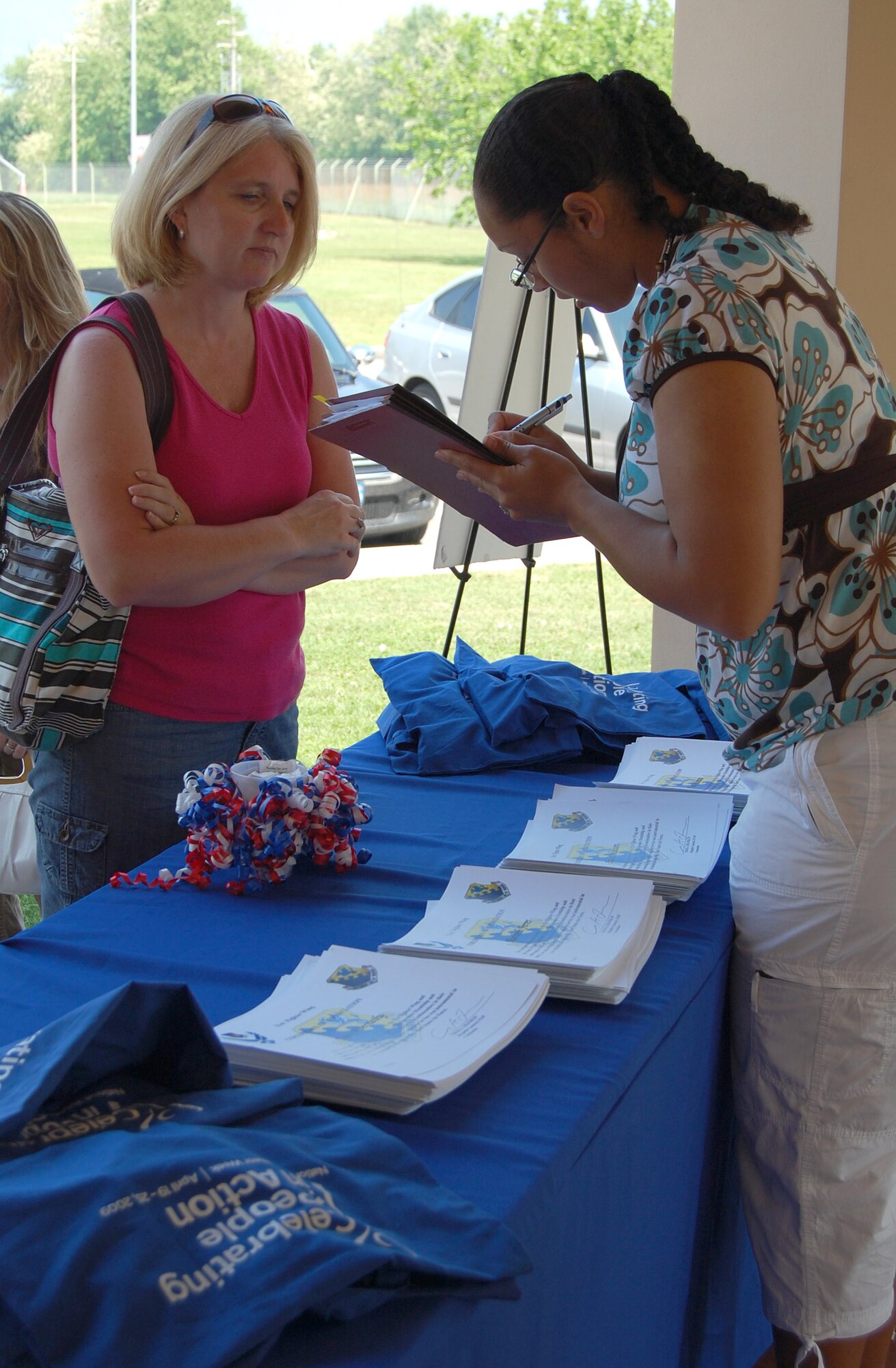 Selina McEwen, a base volunteer, checks in Terri Pritchard, 31st Force Support Squadron Fan Club volunteer, at the annual Aviano Volunteer Recognition Ceremony May 7, 2009 in the Area D pavilion. Last year, base volunteers donated more than 22,225 hours to the base community. (U.S. Air Force photo/Staff Sgt. Lindsey Maurice)