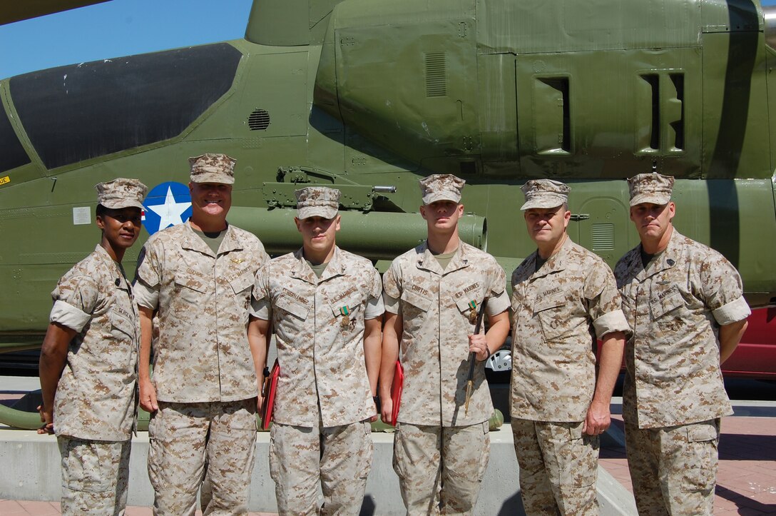 (From left to right) Sgt. Maj. Shelly D. Sergeant, Marine Corps Air Station Camp Pendleton sergeant major, Col. John W. Guthrie, MCAS commanding officer , Lance Cpl. Daniel A. Hernandez communication technician air traffic control, Maintenance Division, Headquarters and Service Battalion, Cpl. Jason E. Curtis, radar technician ATC, Maintenance Division, Headquarters and Service Battalion, Maj. Gen. Michael R. Lehnert, Marine Corps Installations West Commanding General and Sgt. Maj. Jeffery H. Dixon, Marine Corps Installations West sergeant major, stand at a static helicopter display after Hernandez and Curtis were respectively awarded Marine and NCO of the quarter awards. ::r::::n::Curtis was presented with a Navy and Marine Corps Achievement Medal and a noncommissioned officer sword. Hernandez was presented with a Navy and Marine Corps Achievement Medal and a Ka-Bar mounted plaque.::r::::n:: “Our staff noncommissioned officers gave us the tools and our noncommissioned officers set the bar high, and gave us the guidance to reach it,” said Hernandez.::r::::n::Lehnert presented the Marines with their awards during a safety stand down at the air station, May 8.::r::::n:: “When I see these young Marines distinguishing themselves like this, it puts me at ease about leaving the Corps in their hands when I retire,” said Sergeant.::r::::n::